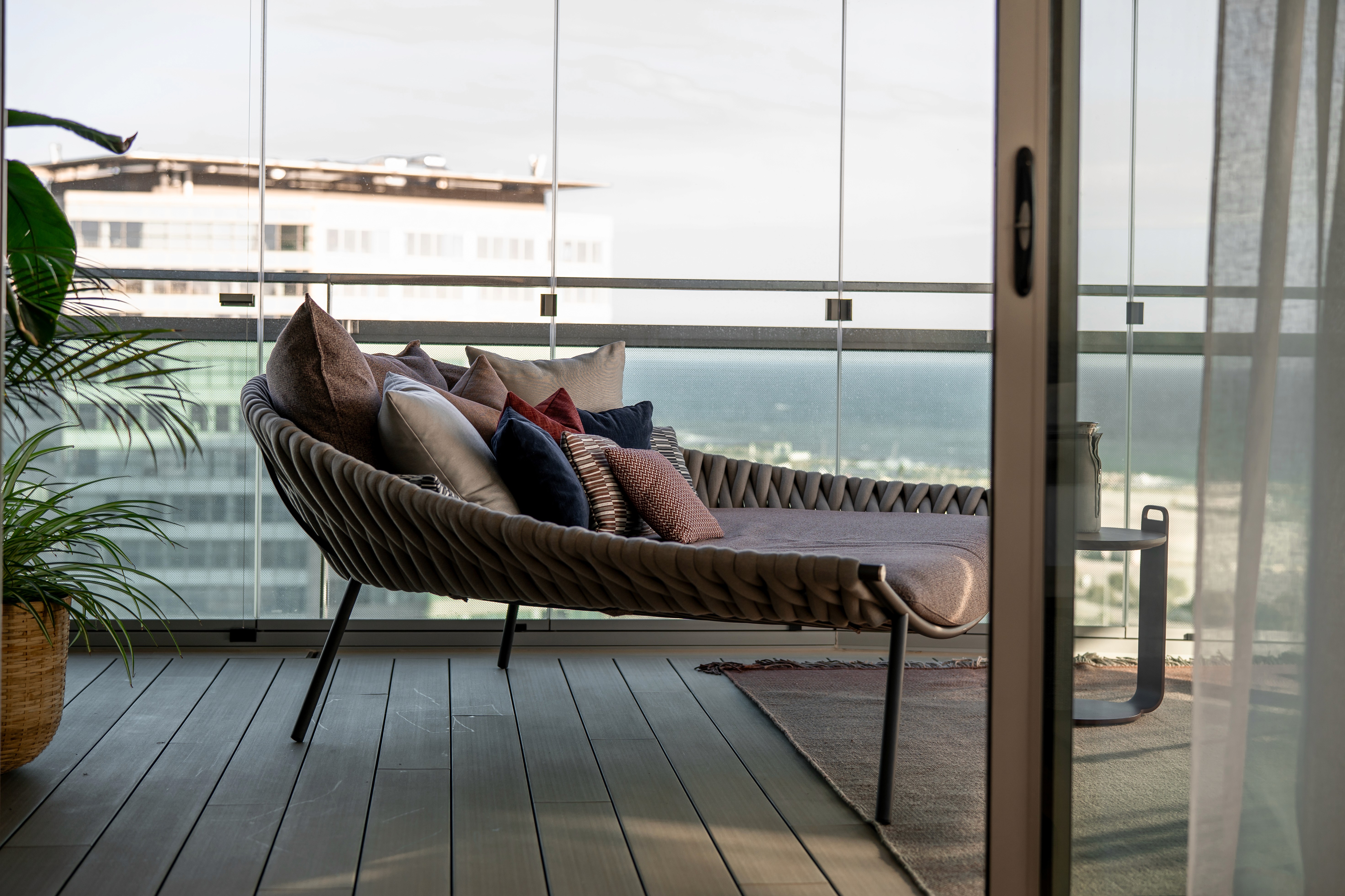 Sofa en terraza acristalada con vistas al mar