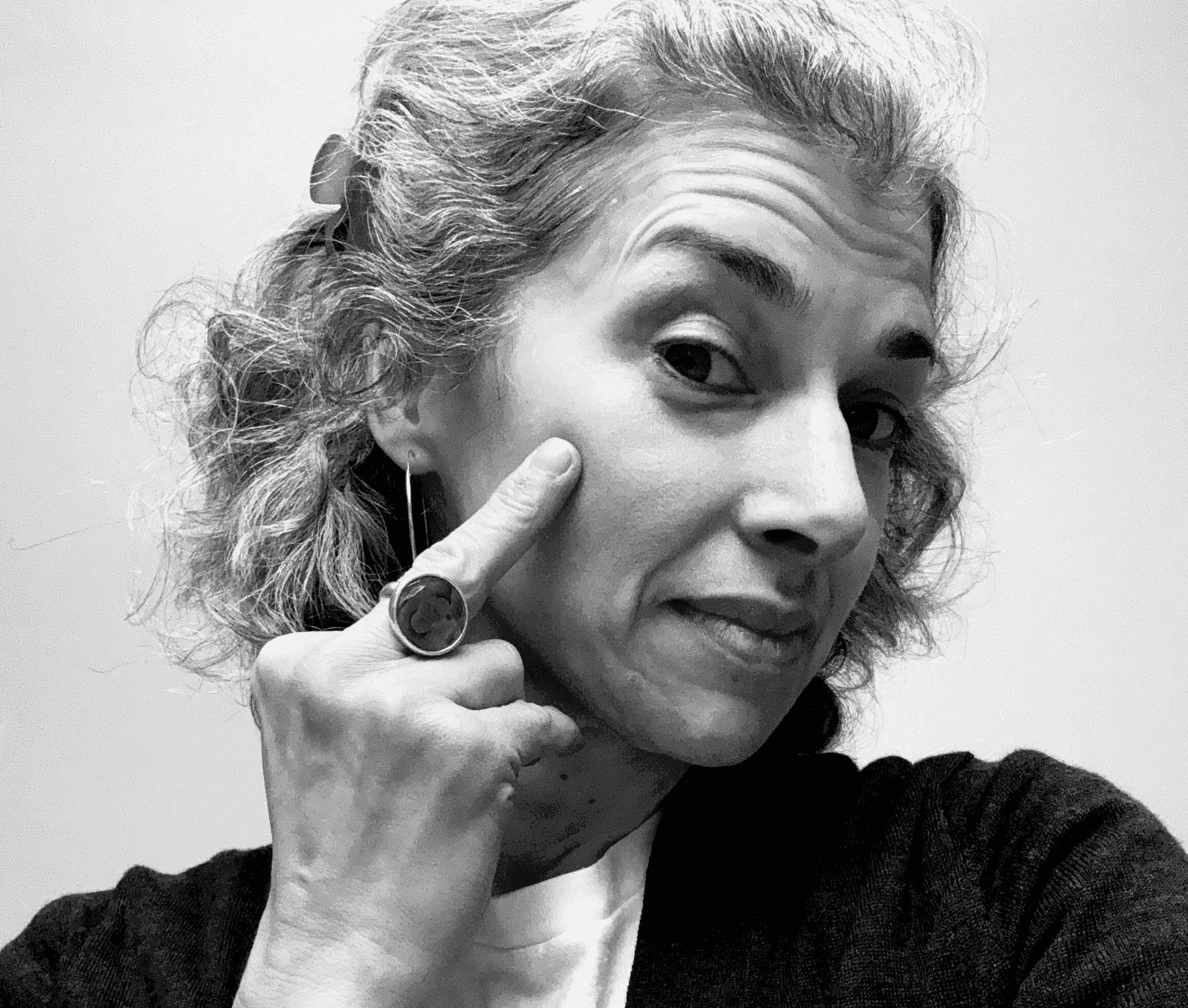 A lady scratching her face with her bird finger. Self portrait by Rafia Mahli, 2025.