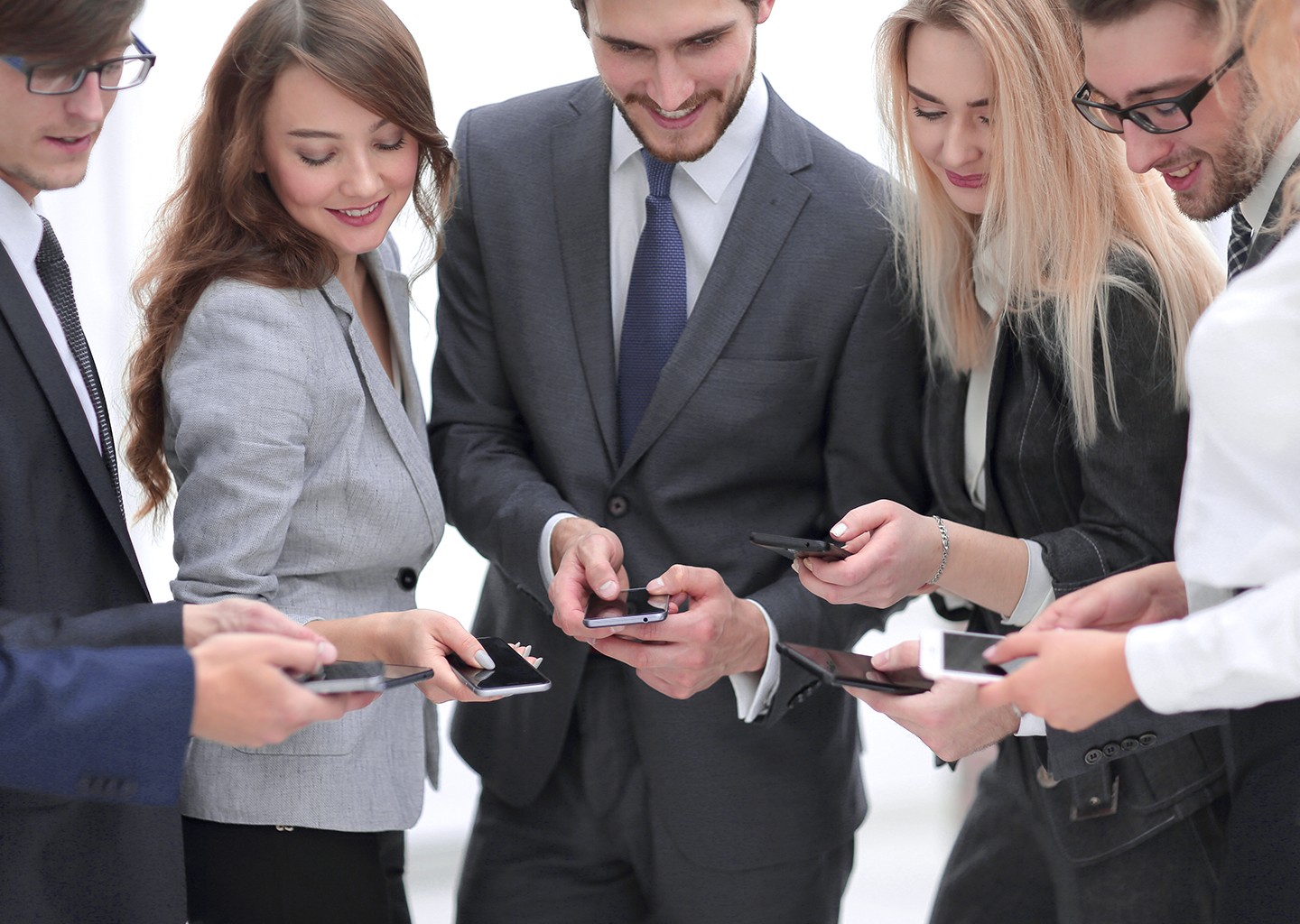 Dipendenti felici con lo smartphone in mano che si scambiano sguardi sui display compiaciuti del nuovo ruolo di Fluida nella loro azienda