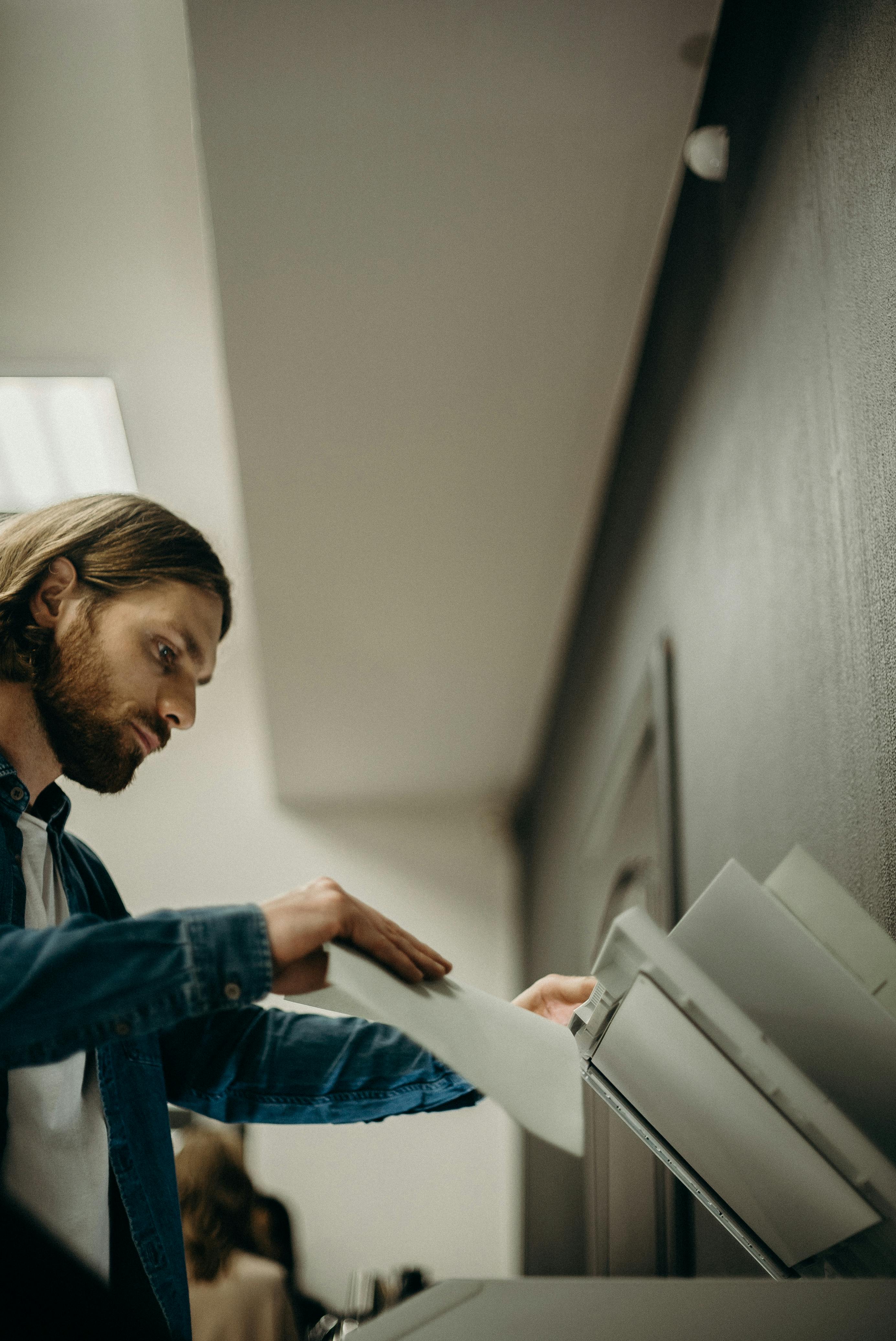 Person using a Xerox machine to photocopy a contract in an office environment.