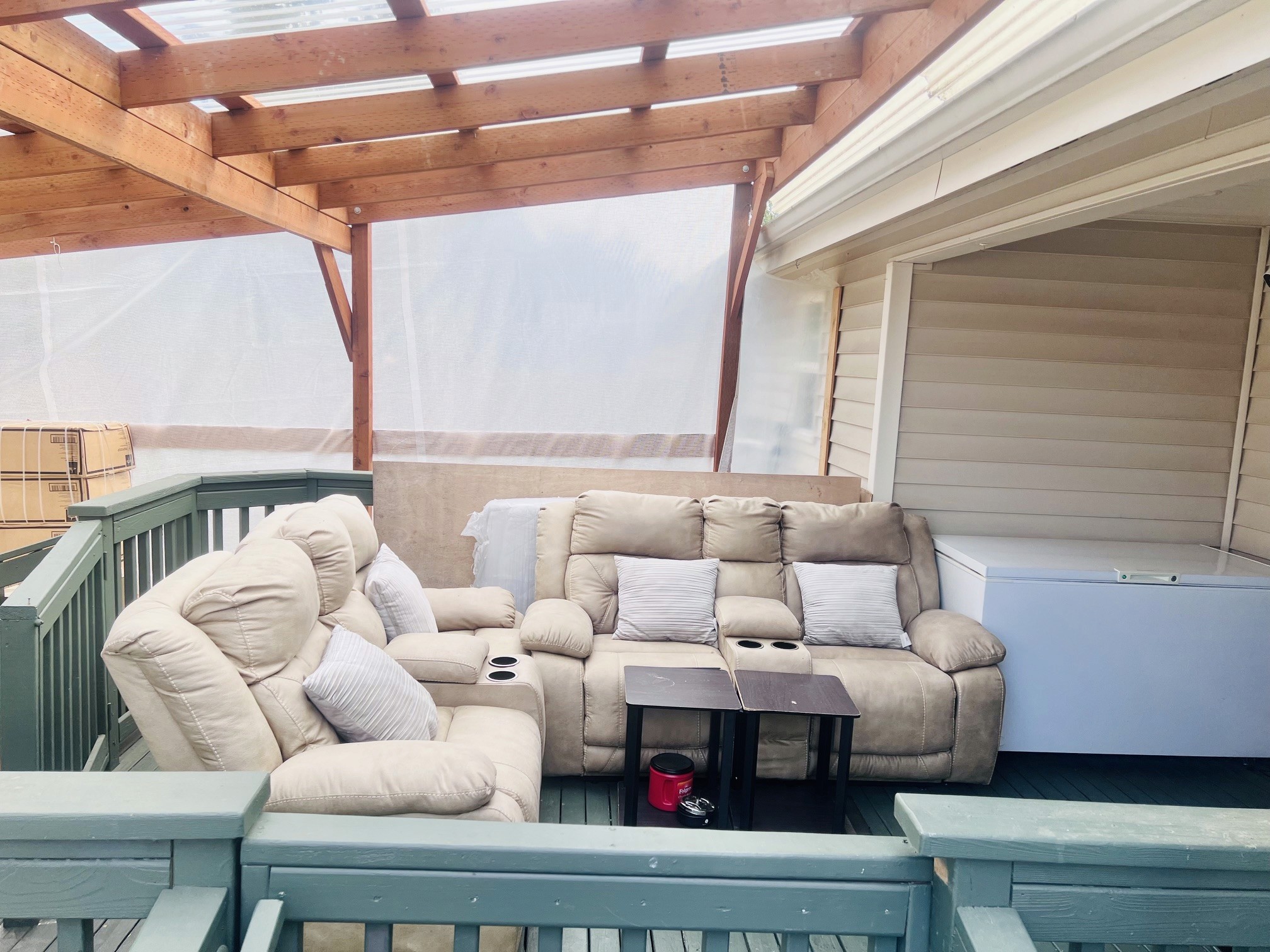 The covered patio: cushioned reclining sofas under a shaded pergola roof