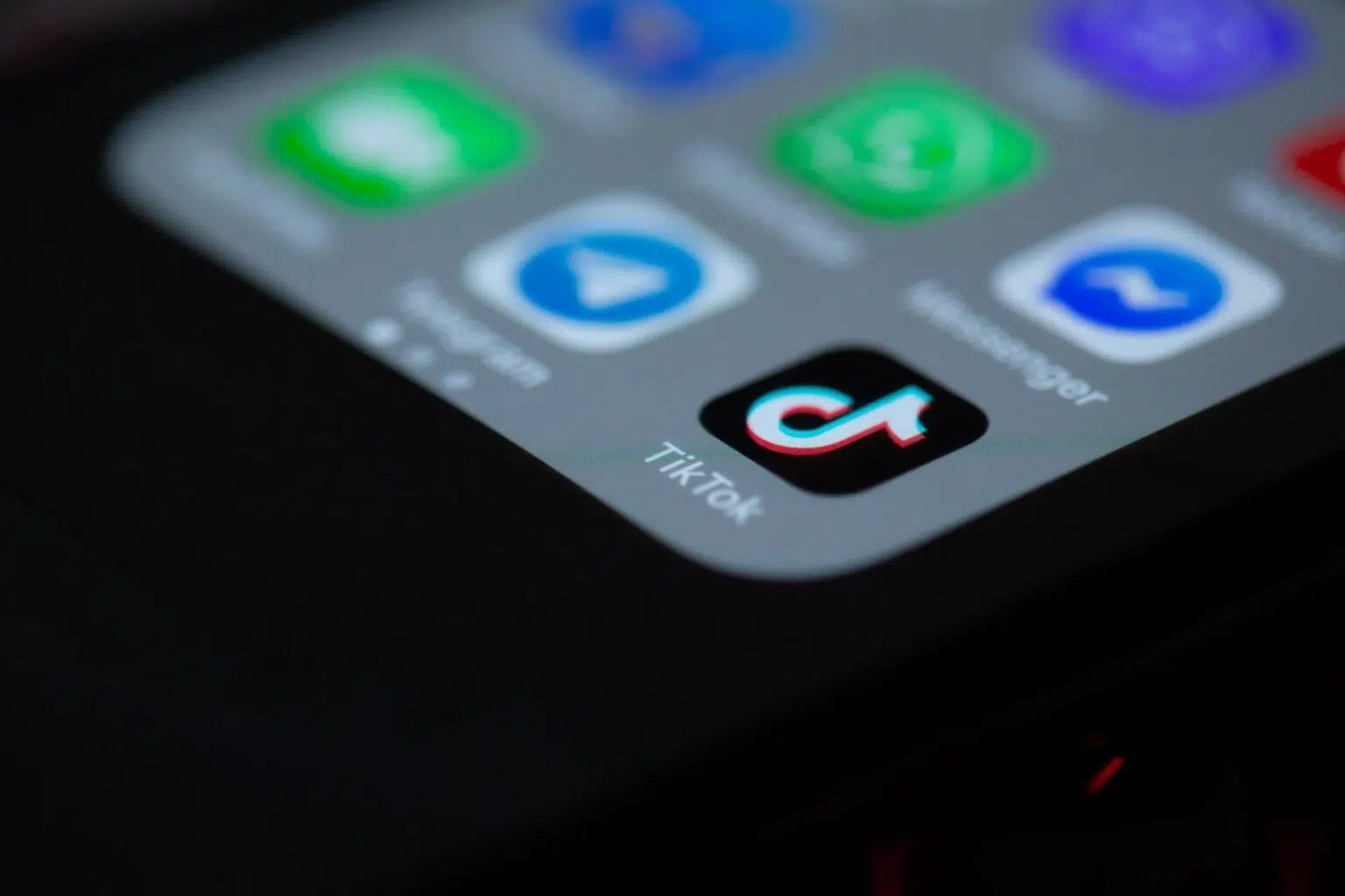 Smartphone with the TikTok app prominently displayed on the home screen