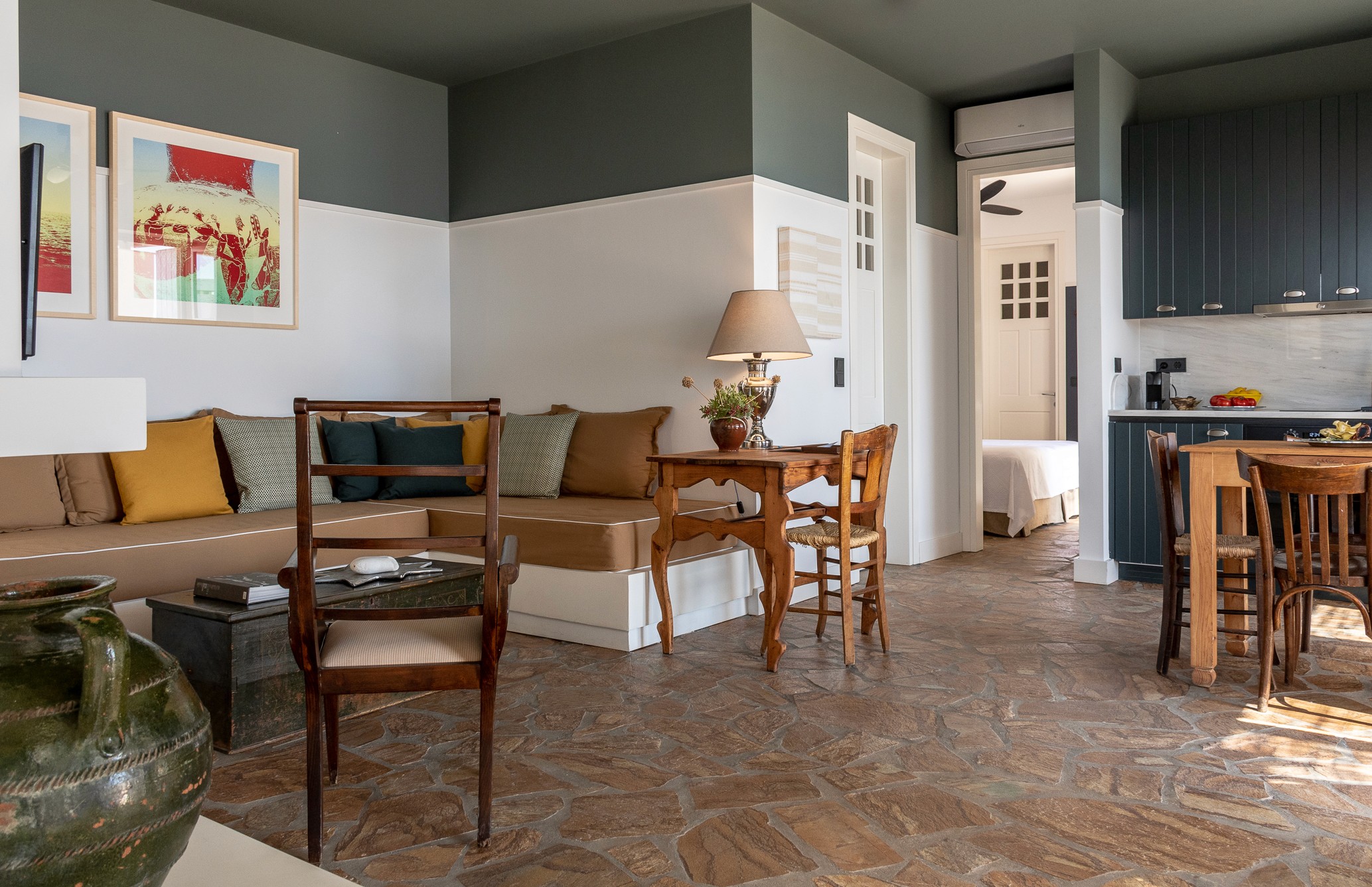 The living room of Rafter Koufonisia Thalassa with a sofa and wooden chairs.