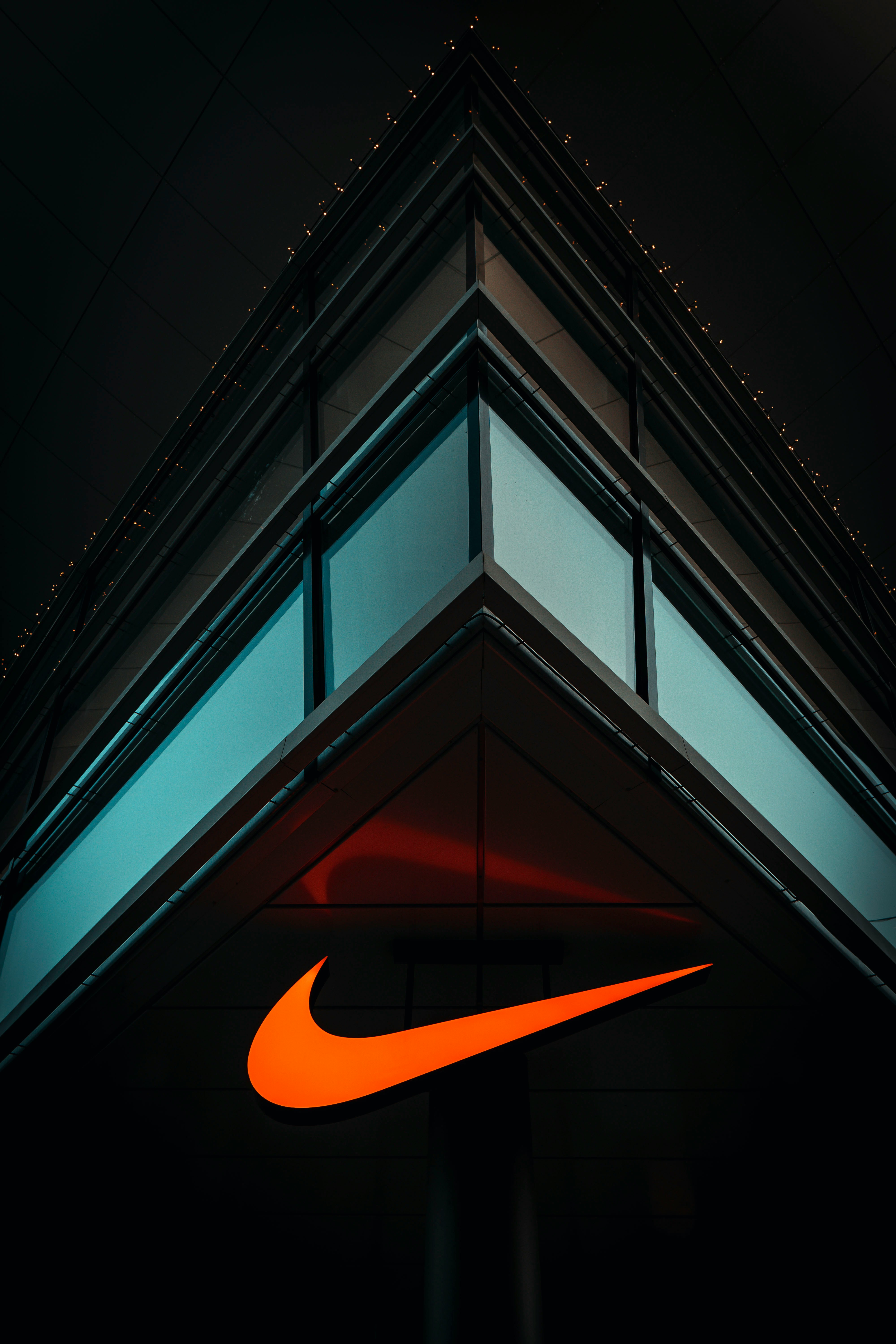 the nike logo is lit up on the side of a building