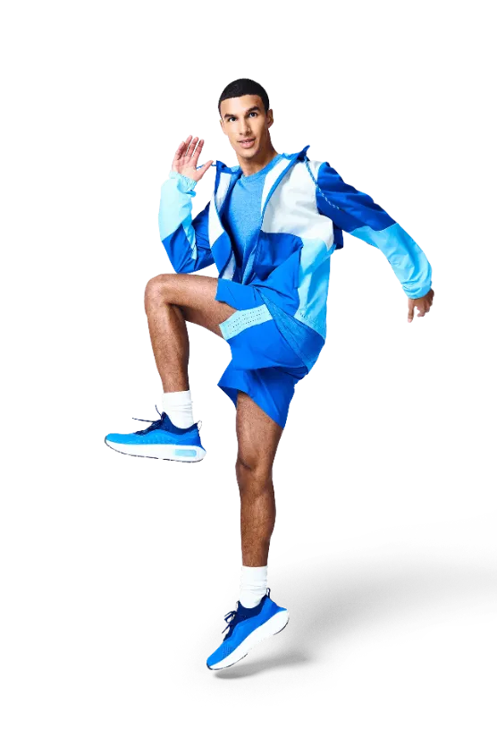 A person in sportswear is lifting one knee while standing on one leg, showcasing a workout or stretching activity.