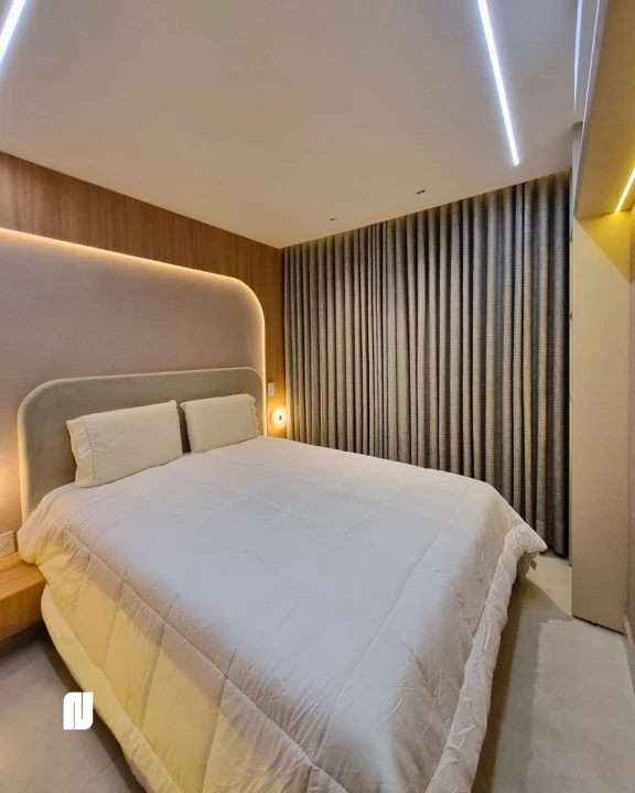 Sala de estar planejada da NS Decor em Anápolis com painel ripado branco, TV, rack suspenso, cristaleira iluminada, lustre dourado e sofás