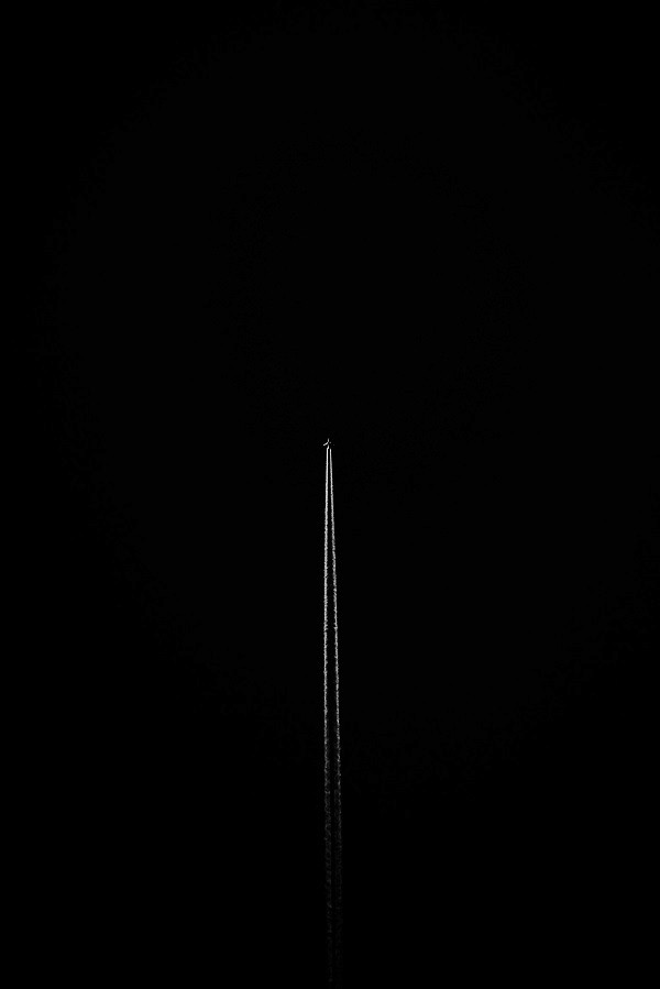 Aircraft contrail in the night sky, evoking exclusive travel experiences and the freedom of luxury concierge services for high-net-worth individuals seeking unique destinations.