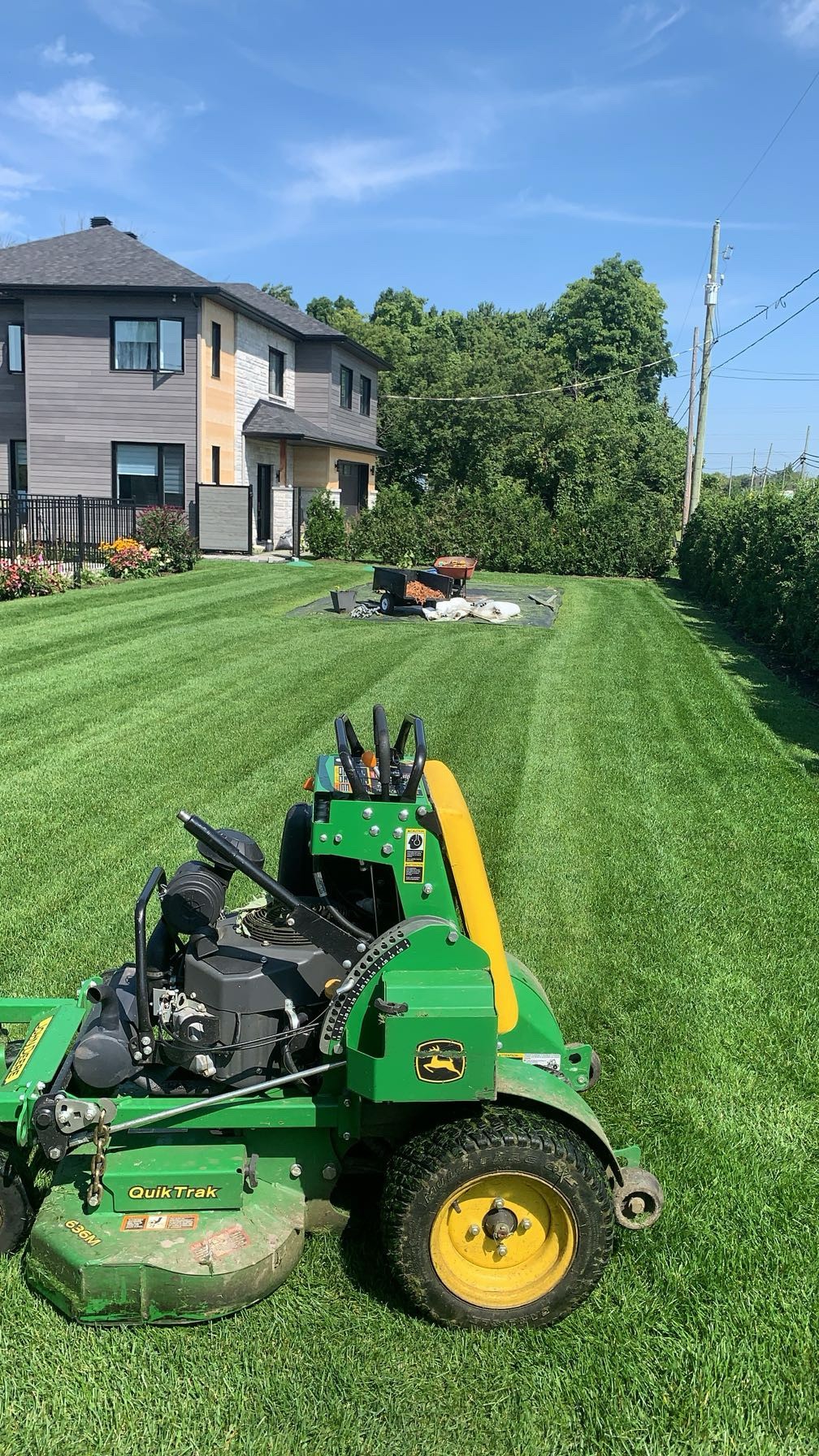 Tonte de pelouse résidentielle avec tondeuse commerciale verte de Pelouse Men Paysagement.