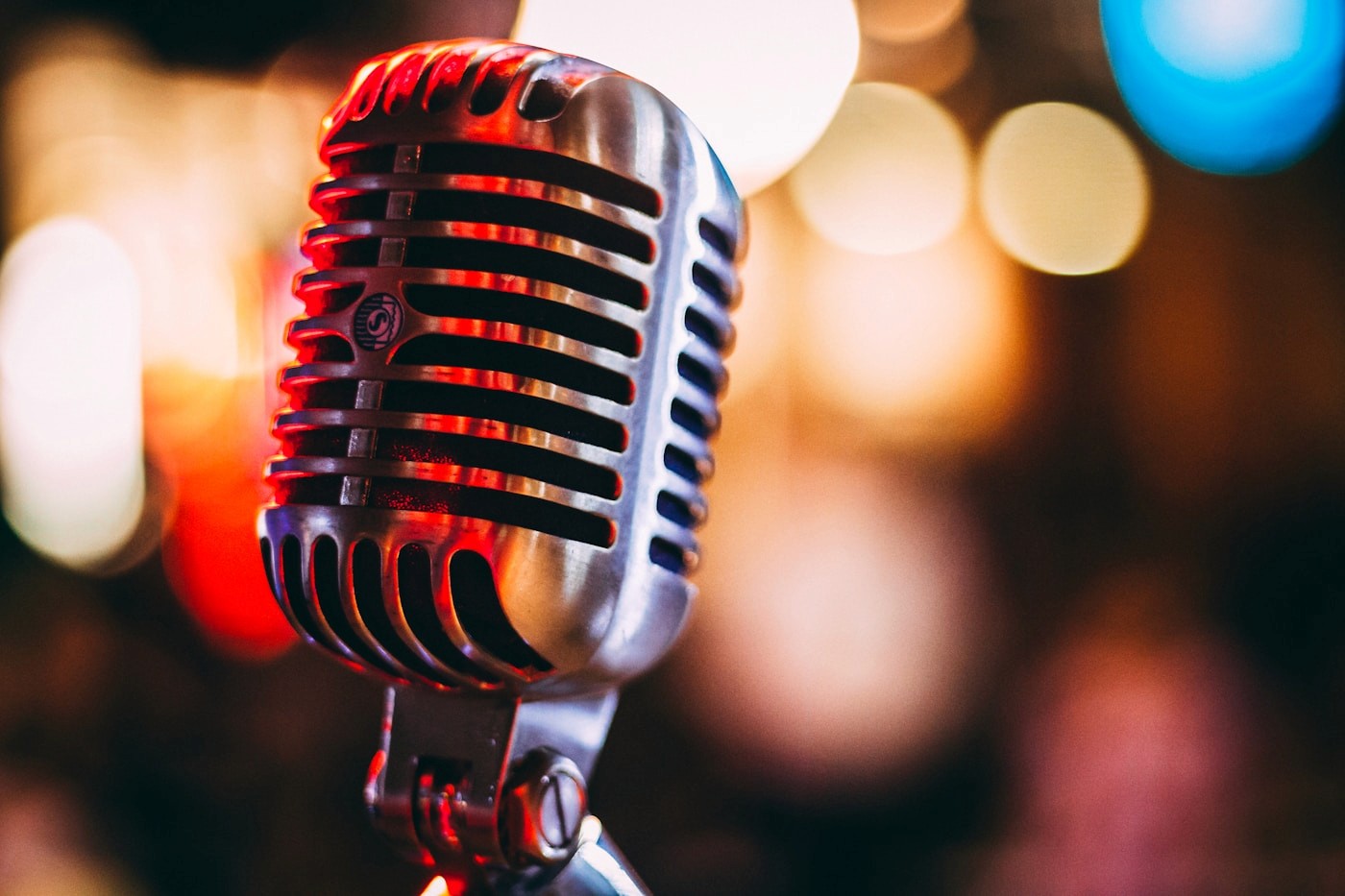 A condenser microphone lit against a dark background