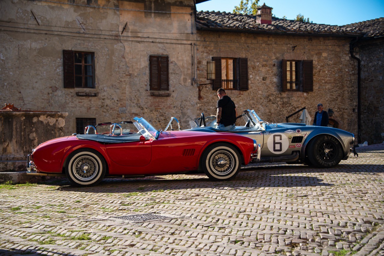 Deux Cobra garées sur les pavés devant une vieille bâtisse en pierre, road trip Toscane