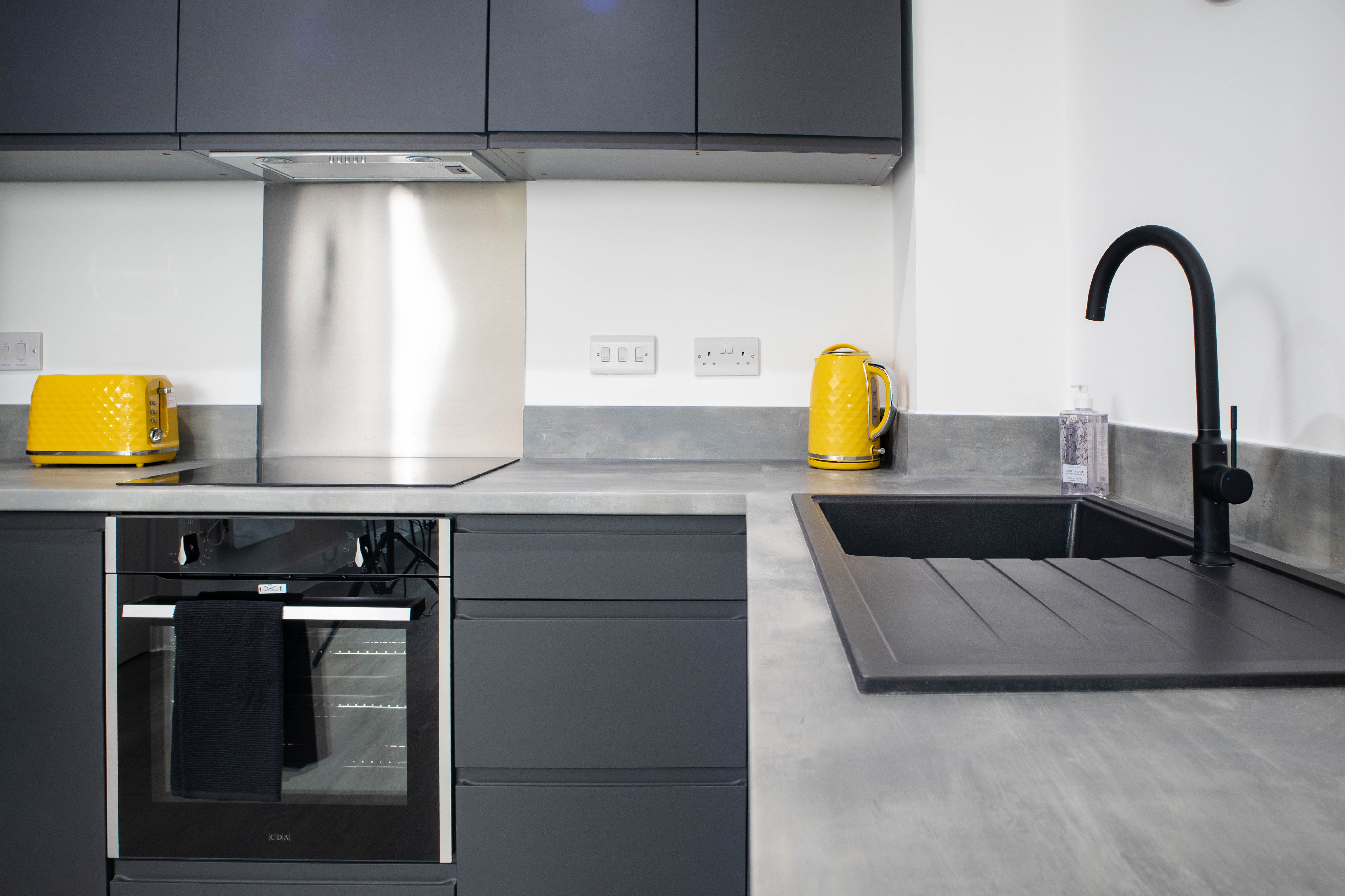 Bright modern Airbnb kitchen with yellow kettle and toaster