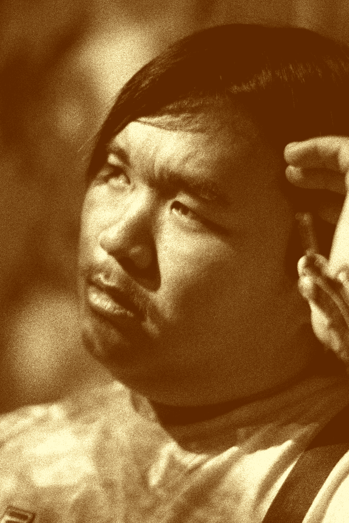 Photo of Evan Saisenesouk holding a Canon XSI Rebel camera in an outdoor garden in Madrid