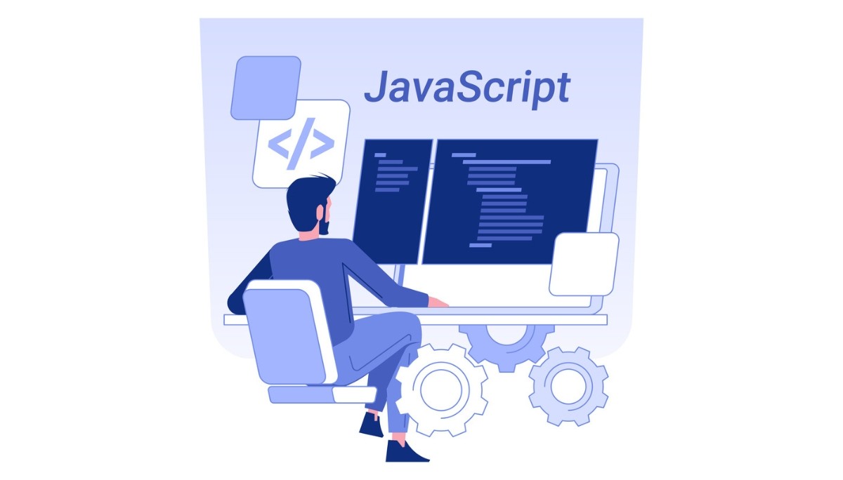 Illustration of a developer sitting at a desk with dual monitors full of code, gears beneath the desk, and a large “JavaScript” header above, representing MERN stack developer roles, skills, and hiring trends for 2026.