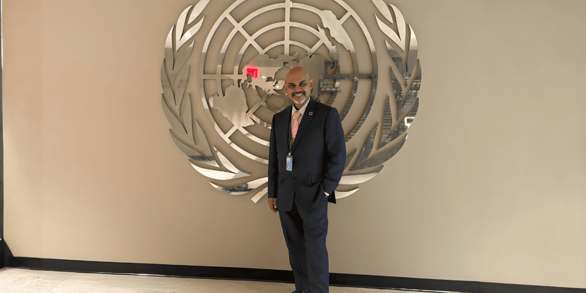 Suman Roy stands proudly in front of the United Nations emblem, symbolizing his global impact on food security.