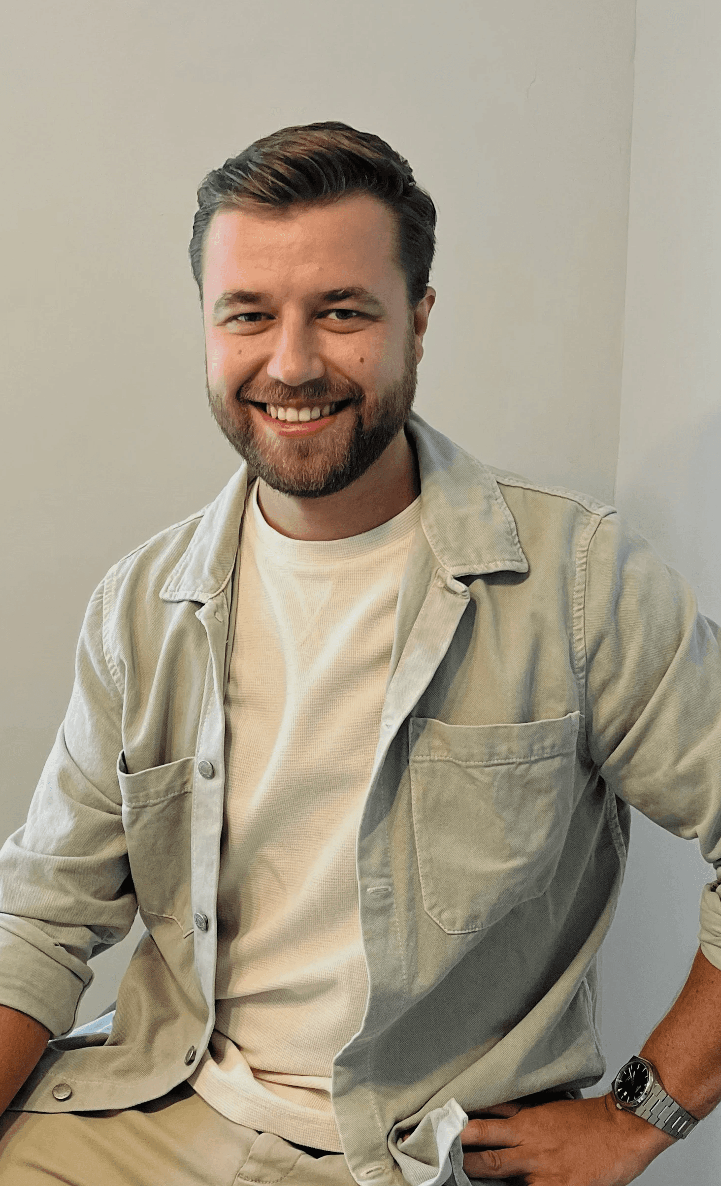 Portrait of a laughing person with curly hair wearing a white shirt