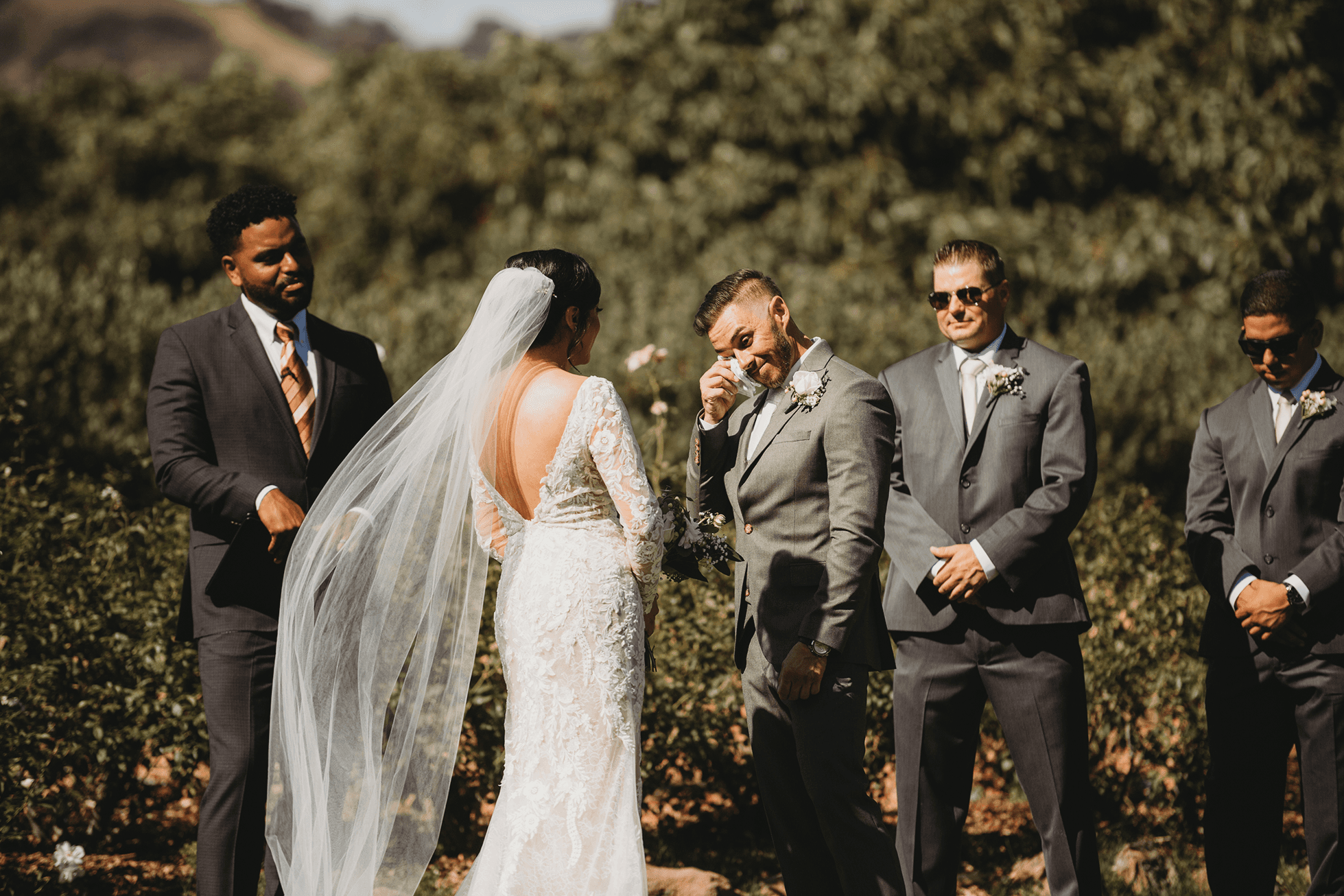 Groom wiping a tear during wedding ceremony