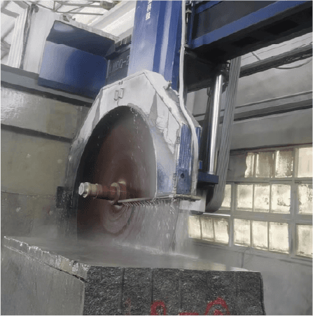 Close-up of the LMDQ-2500 machine's blade cutting through granite, with water jets aiding the cutting process. The focus is on the machine's precise cutting action and robust design.