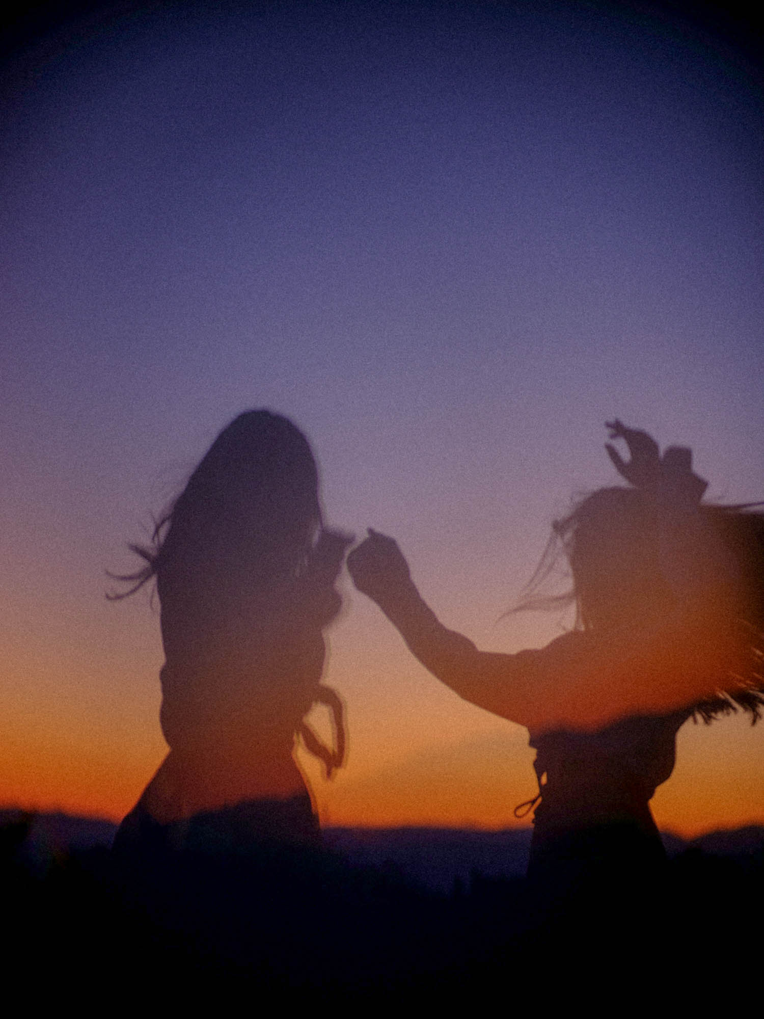 Two people dancing during sunset.