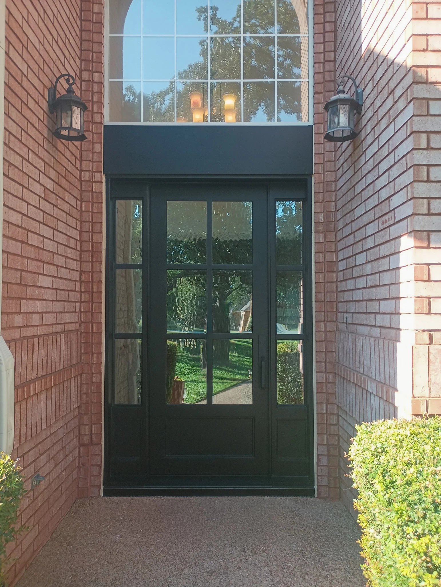 Modern wrought iron pivot door by M2 Iron Doors, installed at a Dallas–Fort Worth, Texas entryway