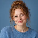Portrait of Nora, smiling woman with red hair in a bun
