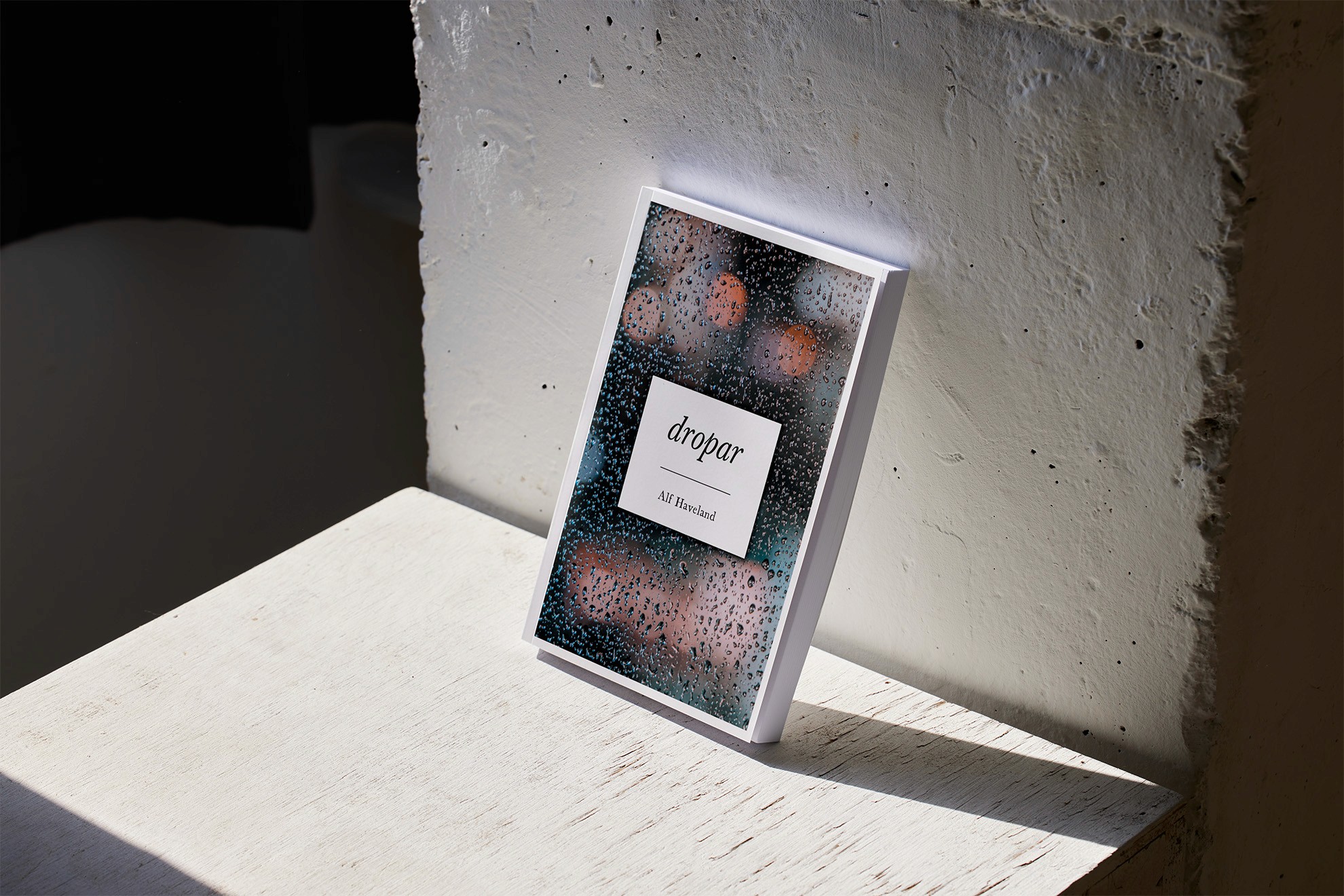 Książka Dropar Alfa Havelanda z okładką przedstawiającą krople deszczu na szybie.
