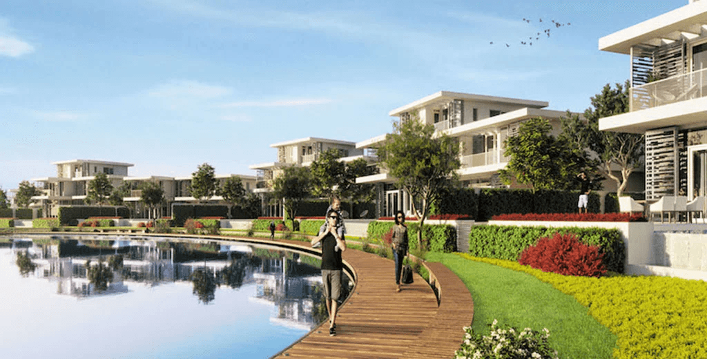 A horse is being handled outdoors by two people.