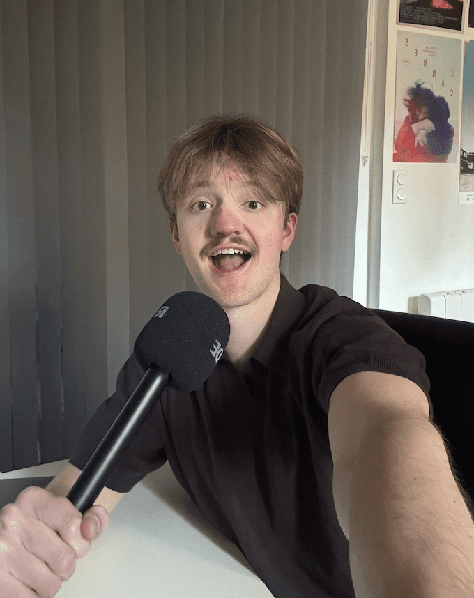 Three individuals gathered around a table, engaged in discussion while examining a laptop.