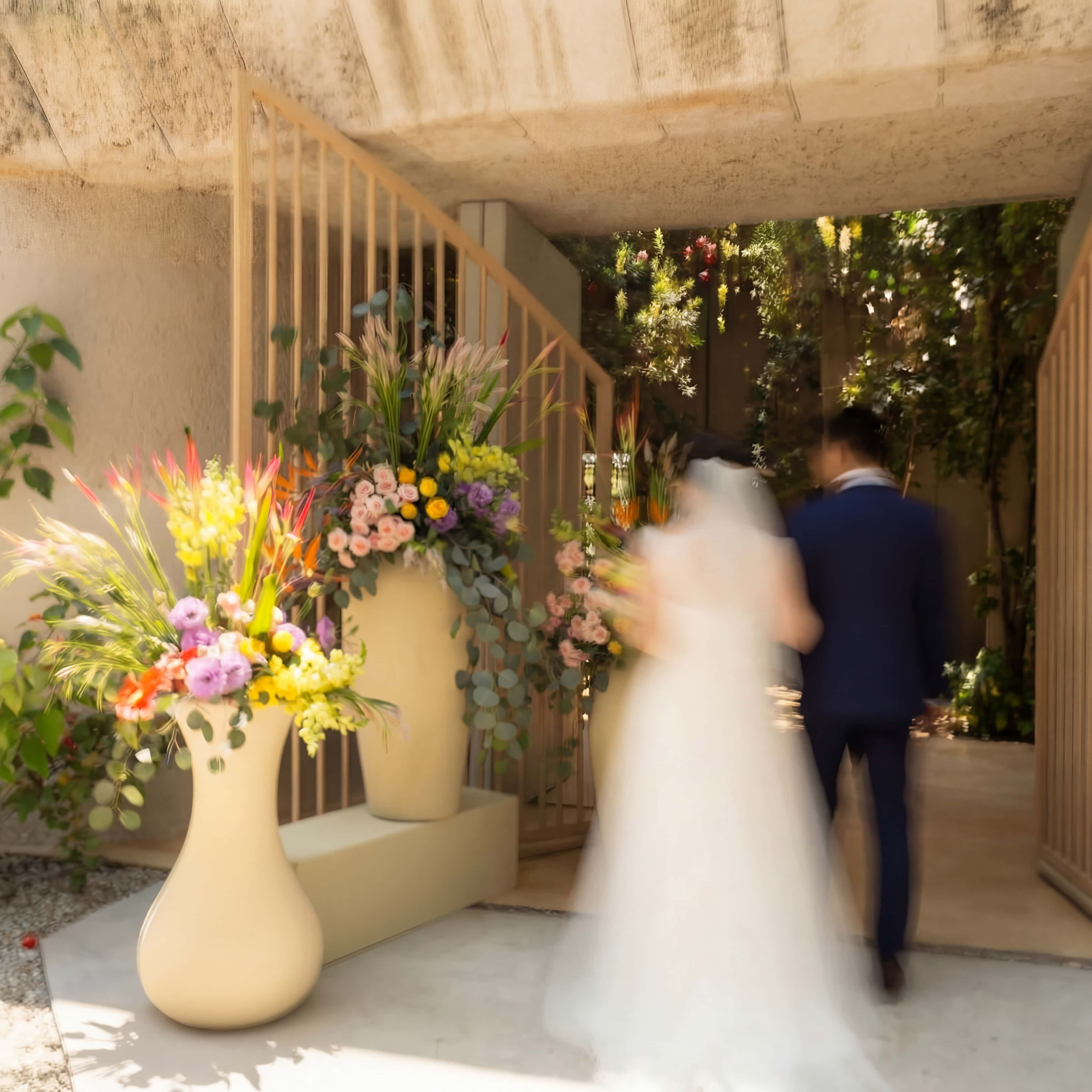 A beautifully set dining table with white tablecloth, cutlery, and fresh greenery in a cozy, well-lit space.