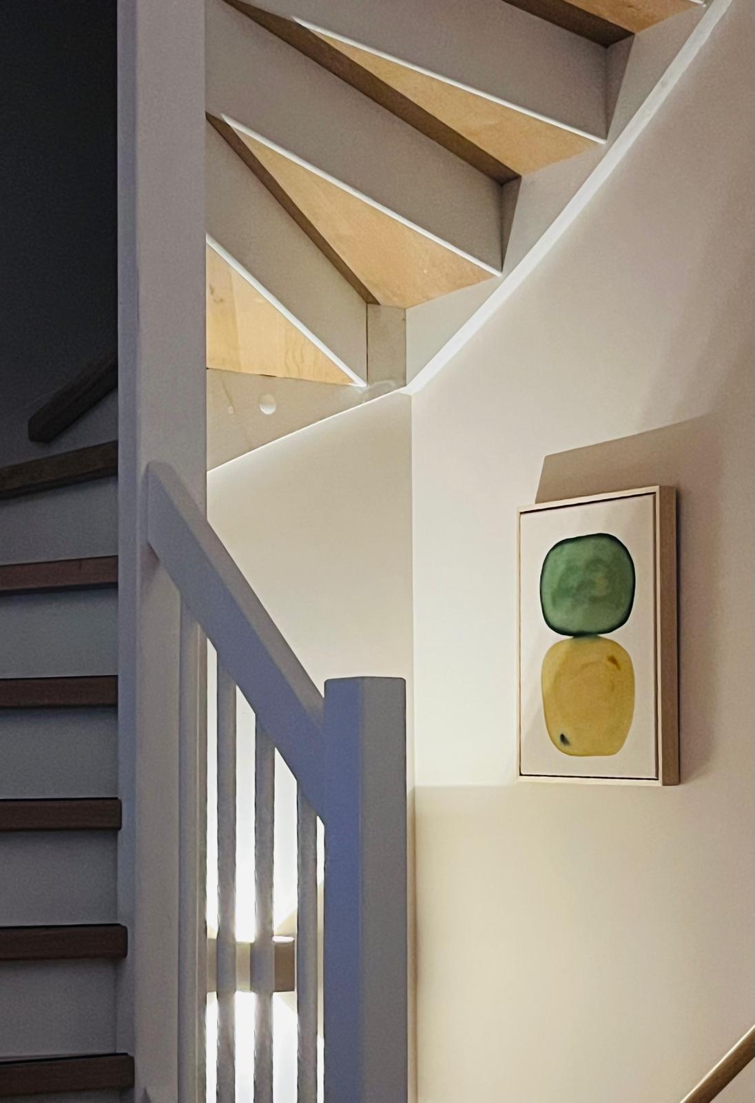 Abstract artwork featuring blue and teal shapes on a white background, displayed in a light-colored frame.