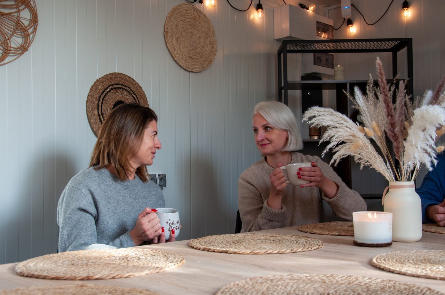 Dwie mamy w strefie relaksu Niedźwiedzia 25, rozmawiające przy kawie w spokojnej atmosferze