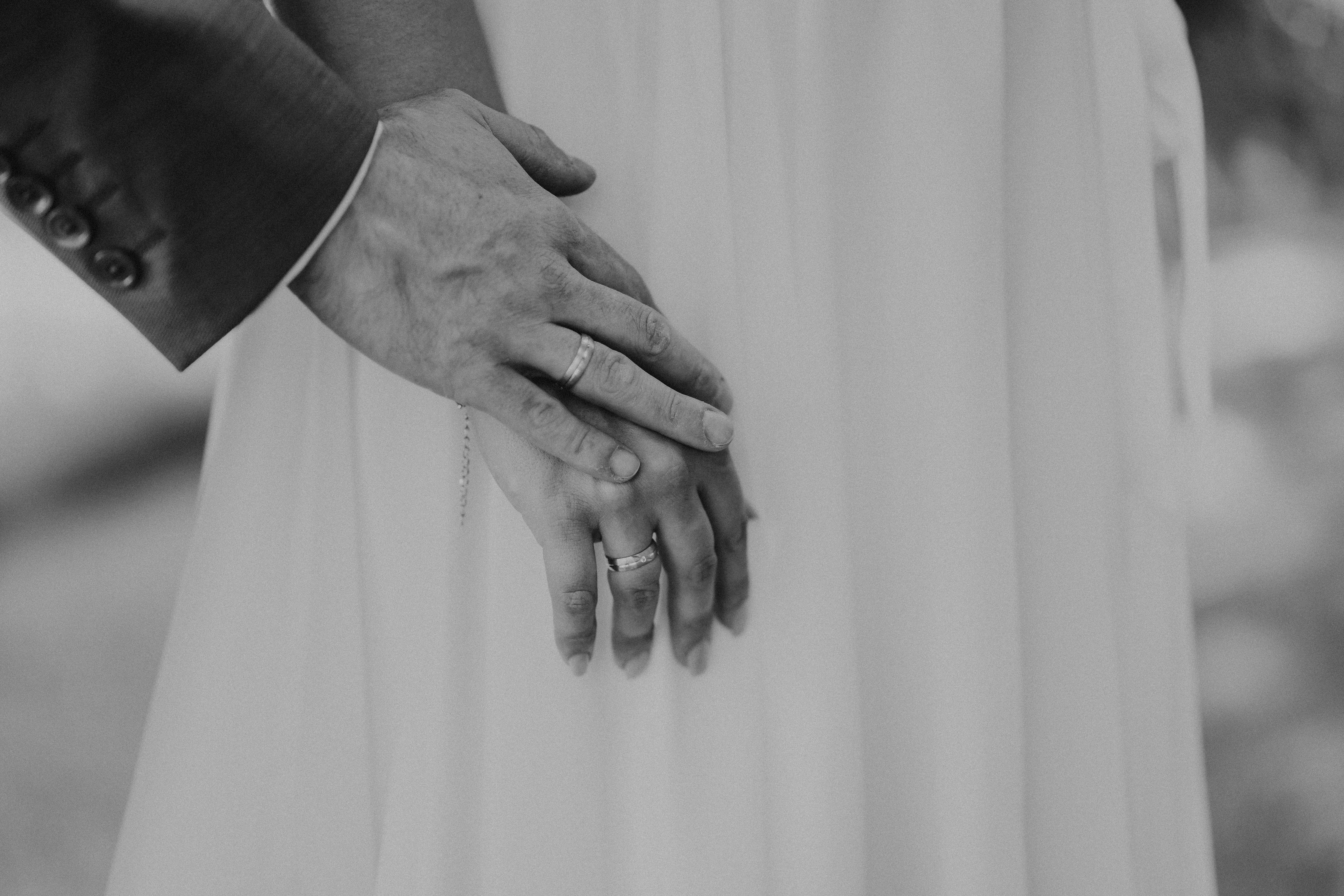 Detailaufnahme Hochzeitsfotografie in Bogen – Hände des Brautpaares bei einem emotionalen Moment.