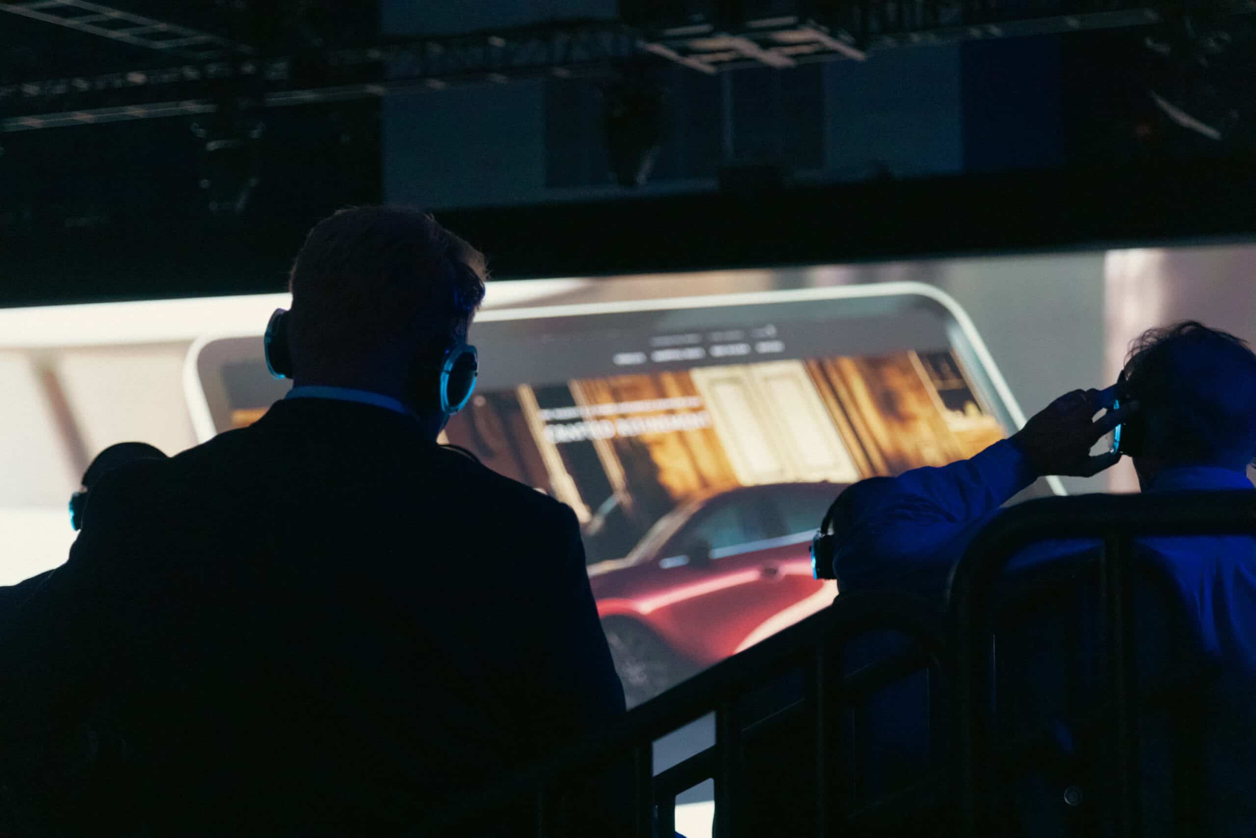 Mazda North America attendees wearing Aural Sound headphones in front of an LED screen