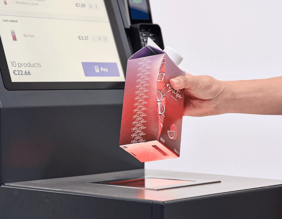 a person scanning a ice tea bottle on a shopreme matrix - self checkout kiosk