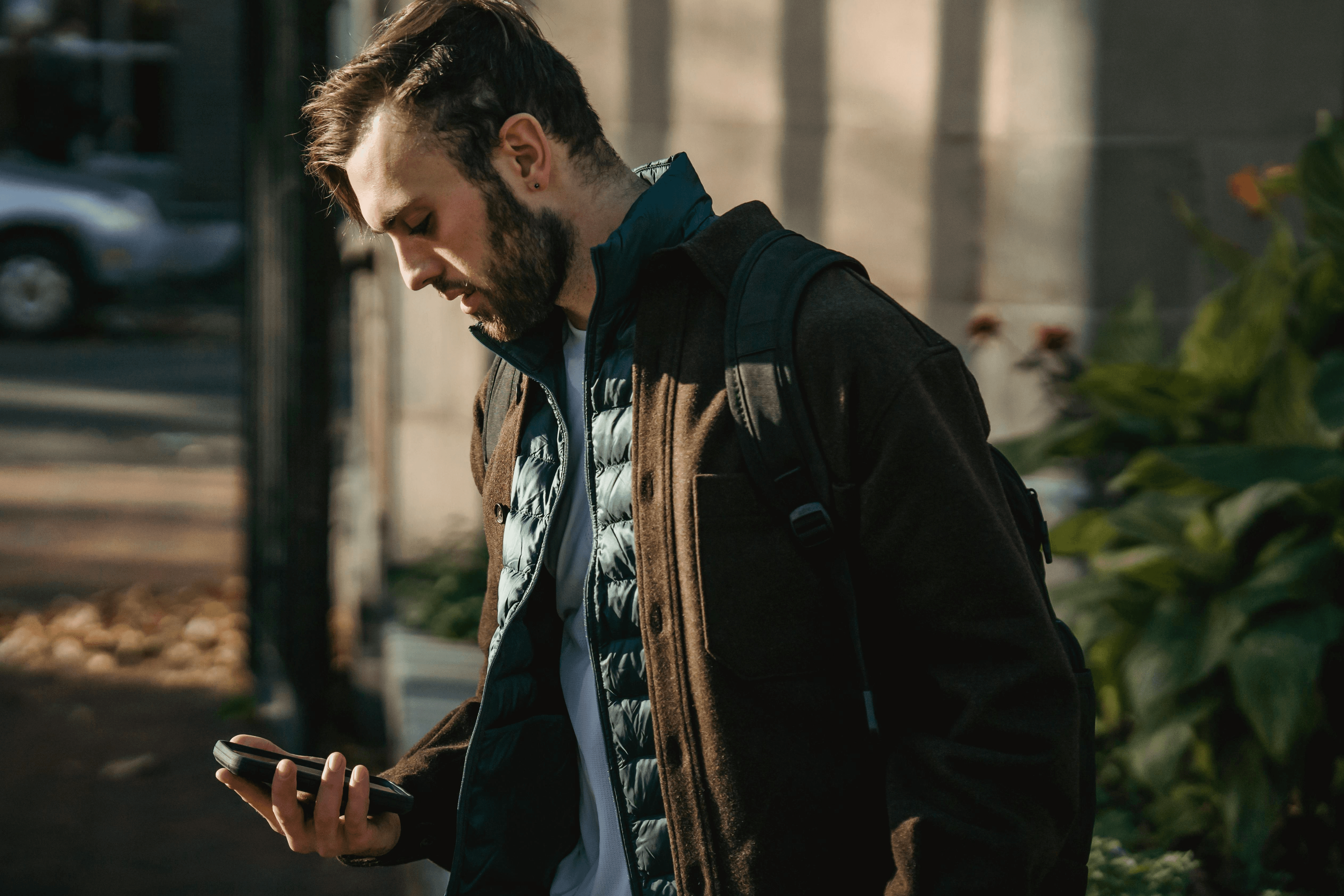 woman in yellow and blue jacket holding silver iphone 6