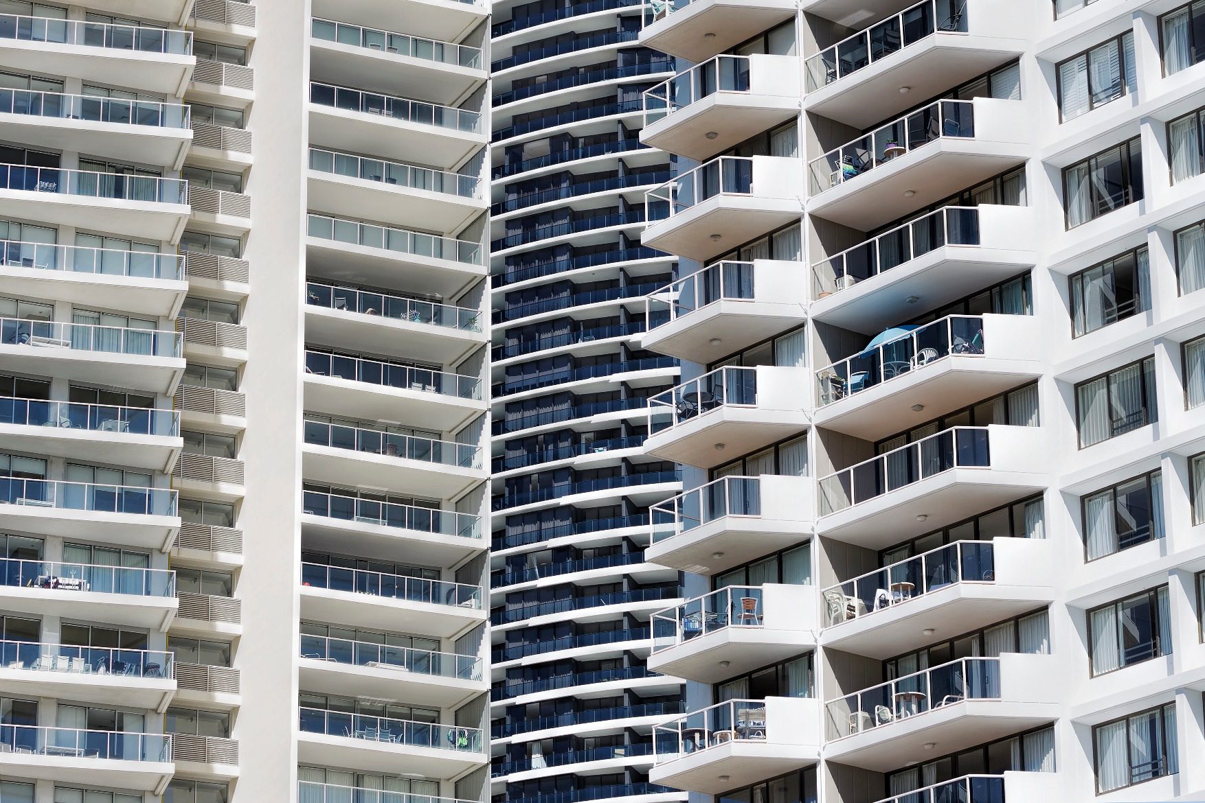 Apartment balconies stacked on a modern high-rise building.