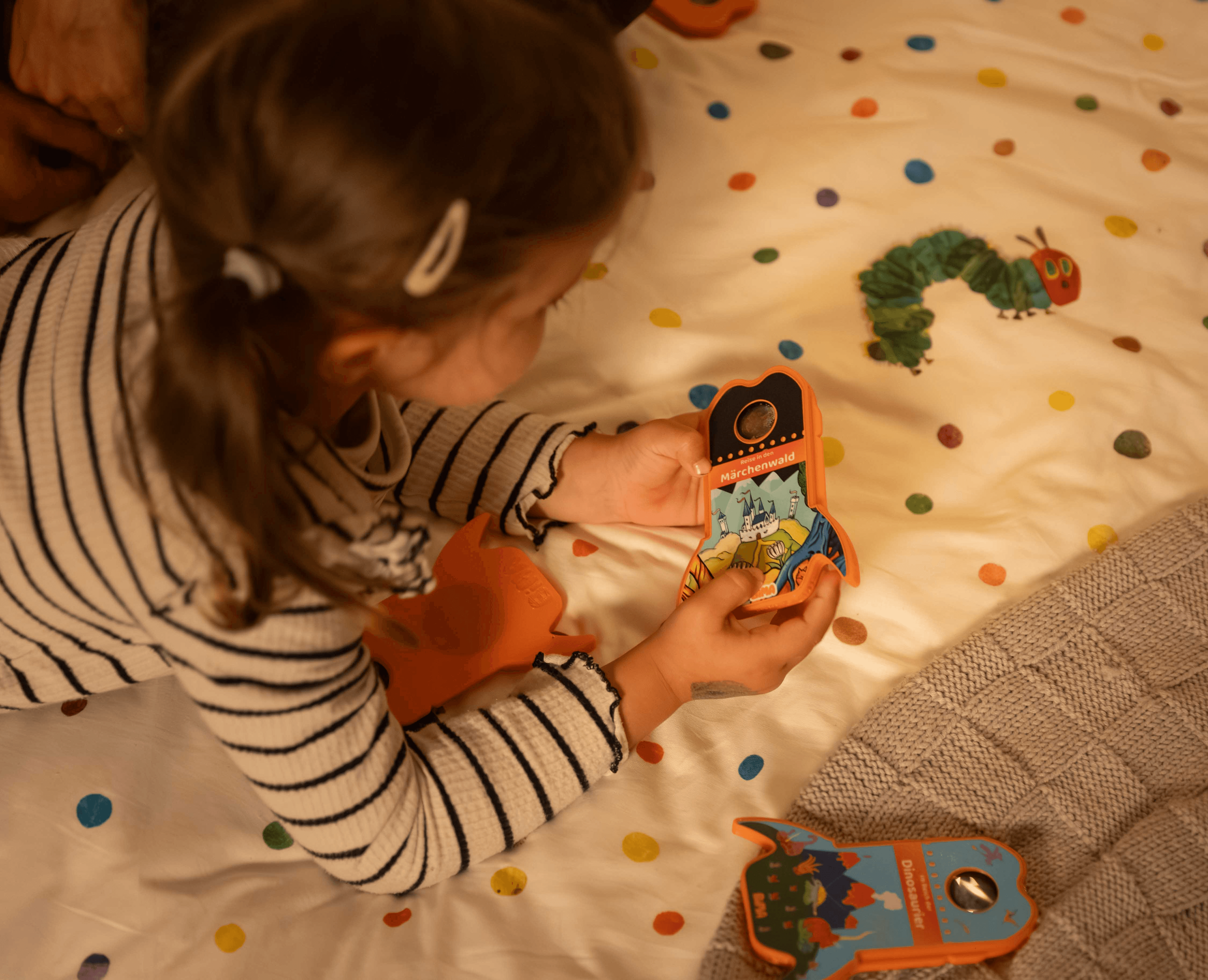 Ein Kind liegt auf dem Bett und schaut sich die BiMA Raketen an