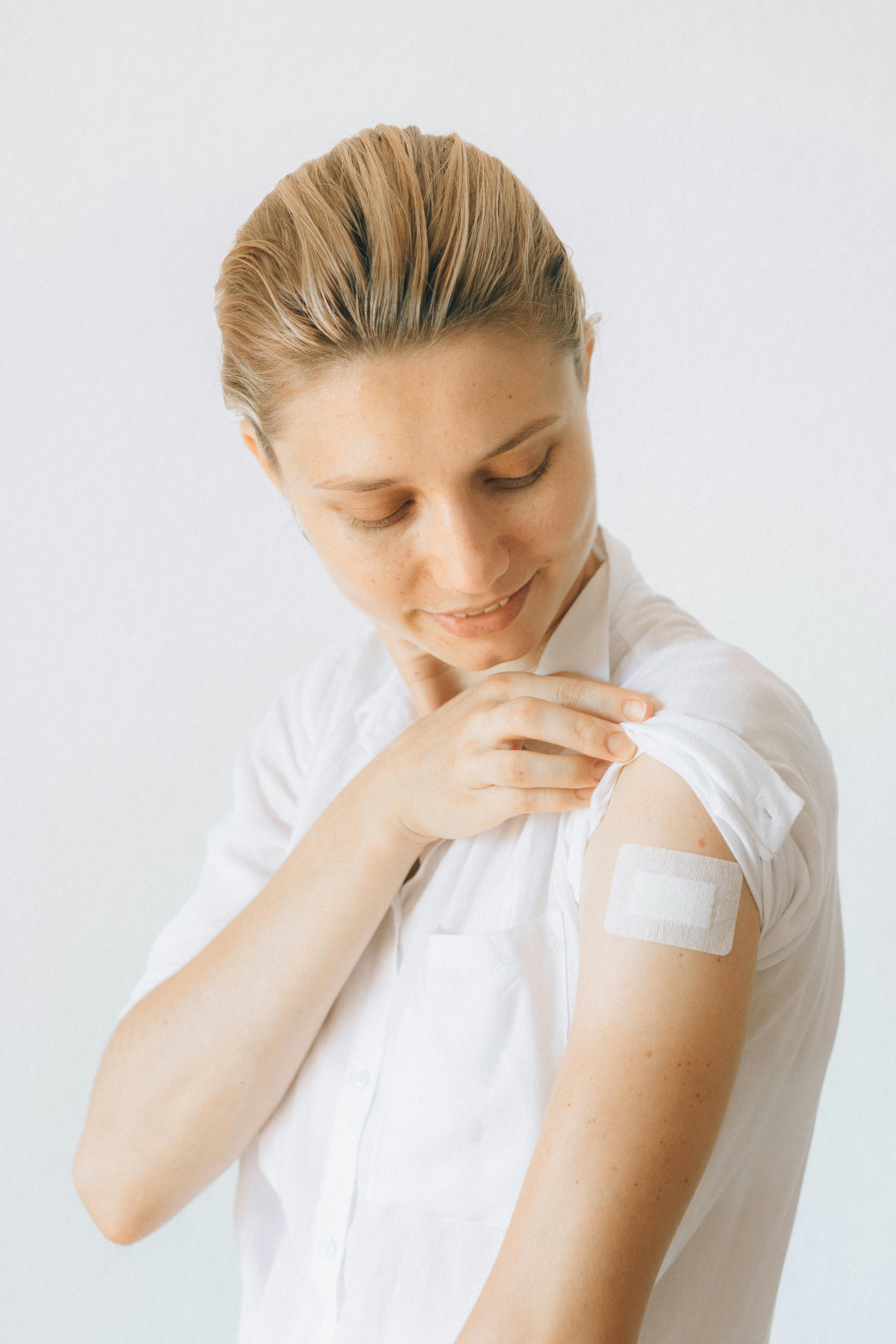 a-smiling-woman-displays-a-bandage-on-her-arm-after-receiving-a-vaccine,-signify - nataliya-vaitkevich (pexels)