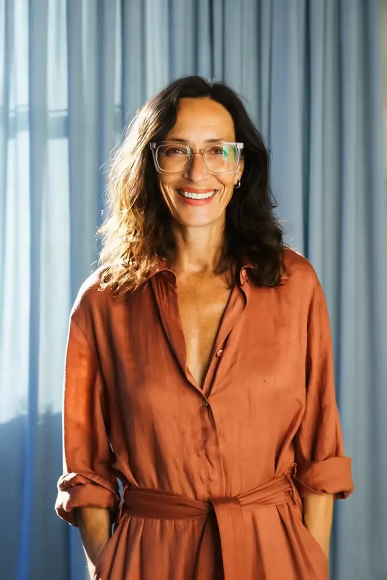 Woman in an orange outfit smiling in natural sunlight