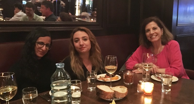 three women sitting at a dinner table