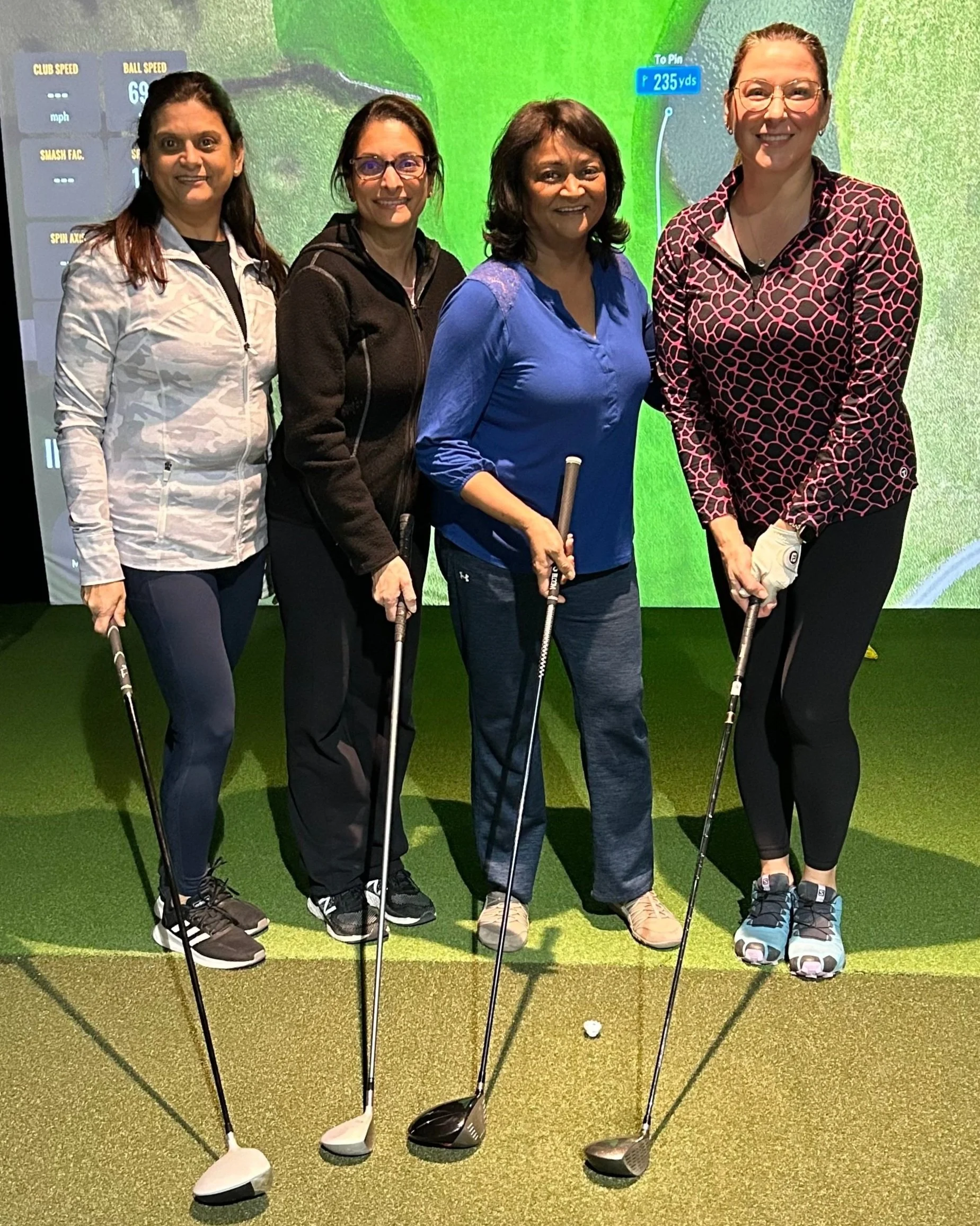 Group standing in front of golf simulator