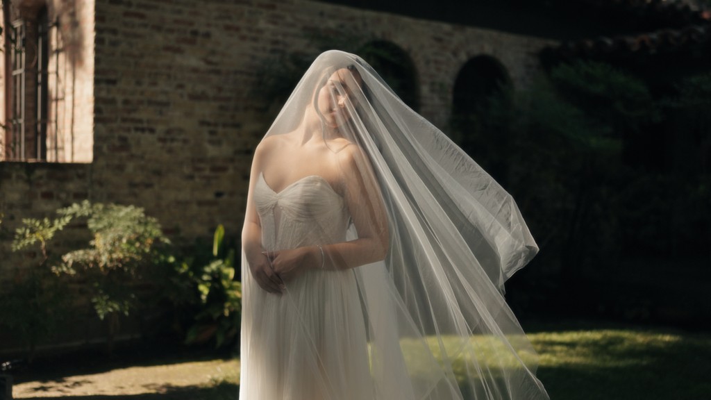 The bride is putting on her earrings.