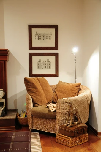 Armchair with a woven throw beside framed prints