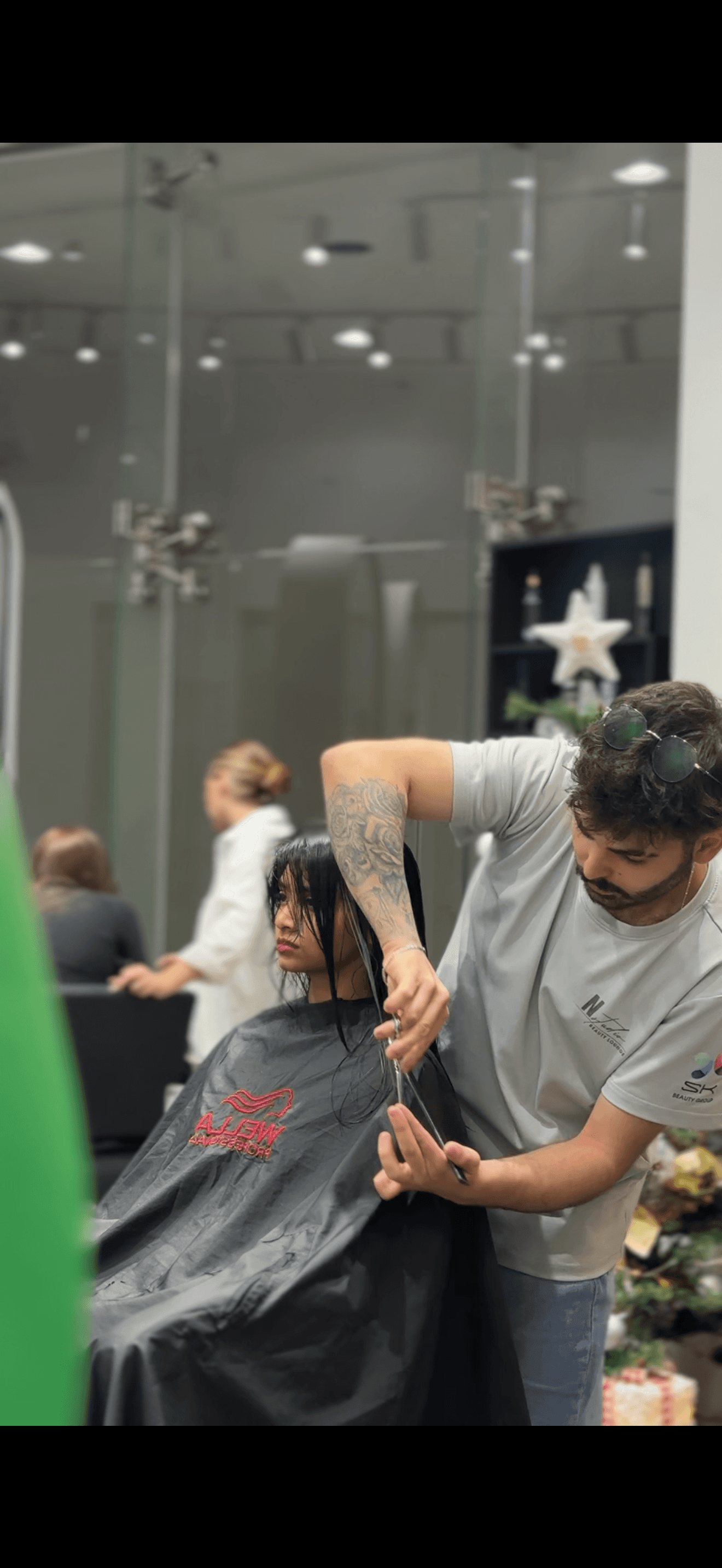 a woman cutting another woman's hair with scissors