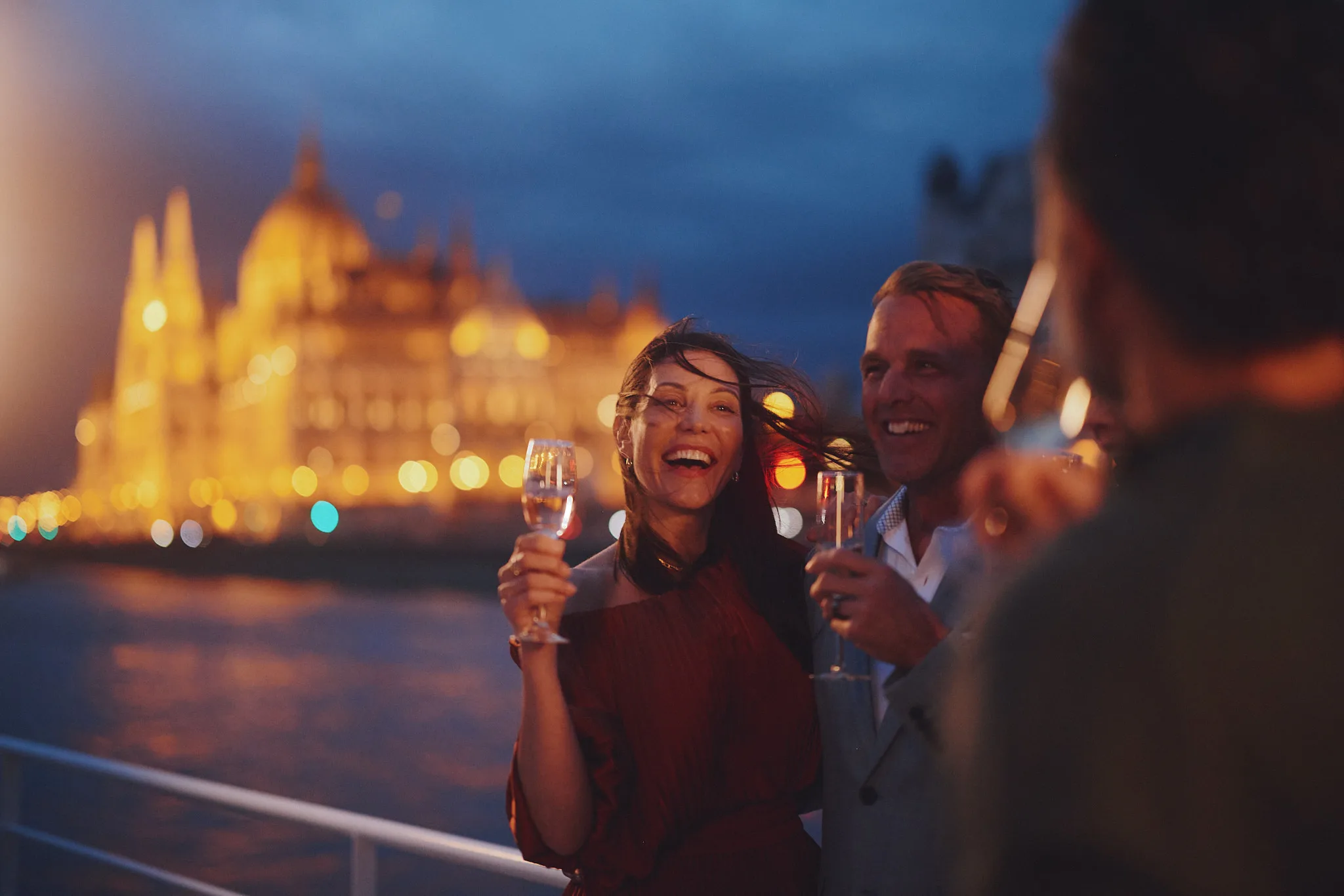 champagne toast on river deck at night — lifestyle photography by Tom Kubik