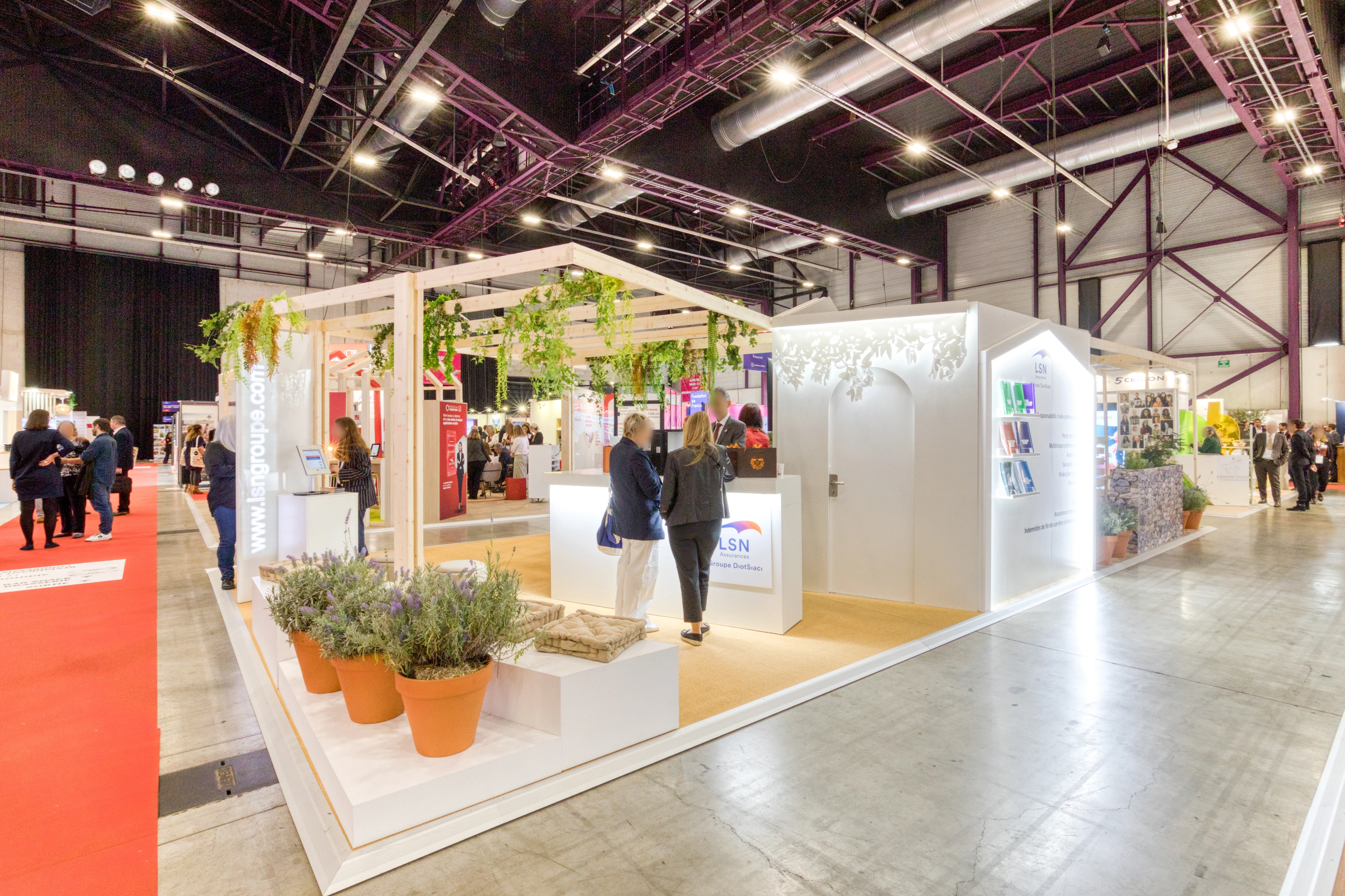 « Entrée du stand LSN Assurances avec arche lumineuse et aménagement végétalisé »