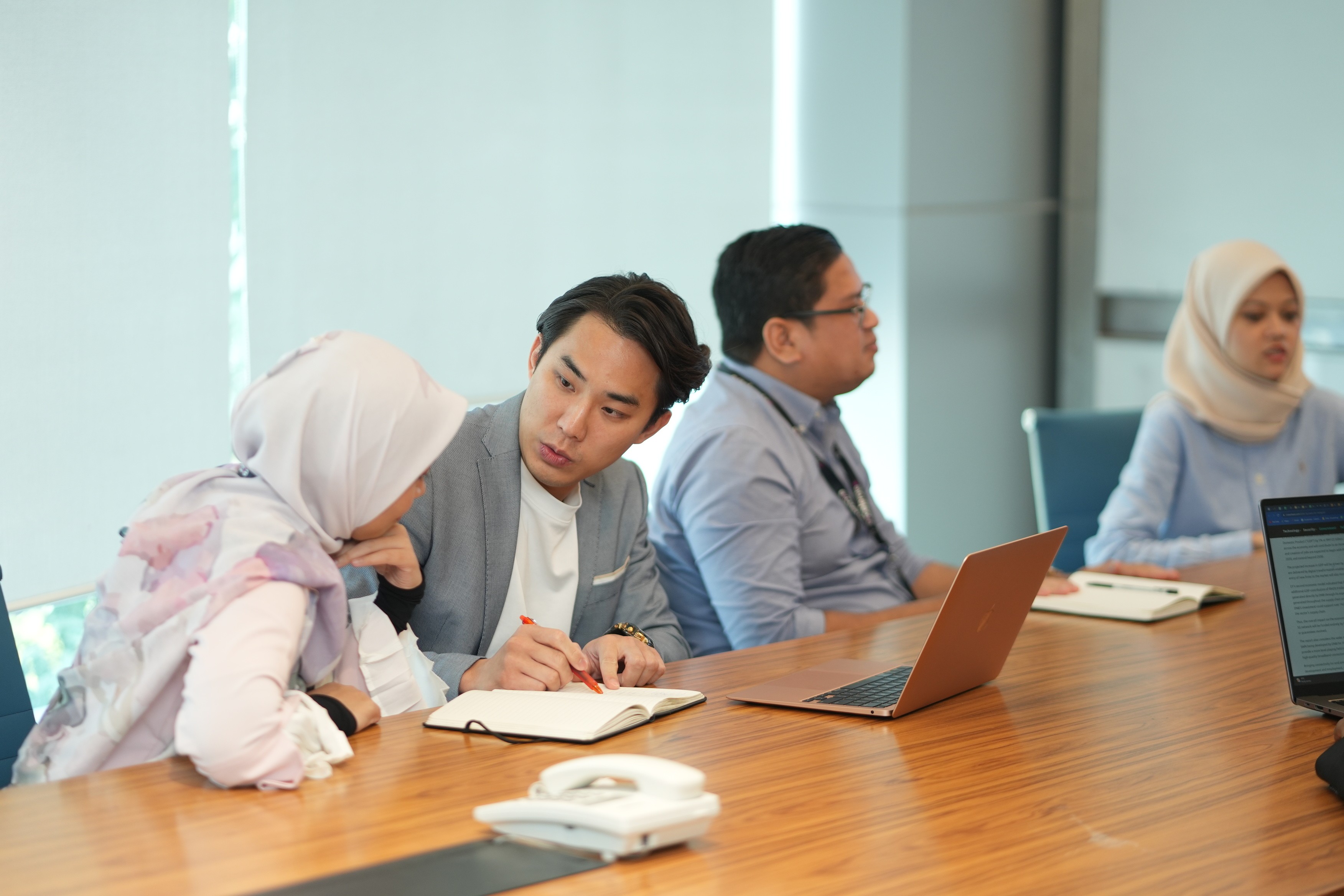 A diverse group of people engaged in discussion around a table, collaborating on innovative customer service solutions.