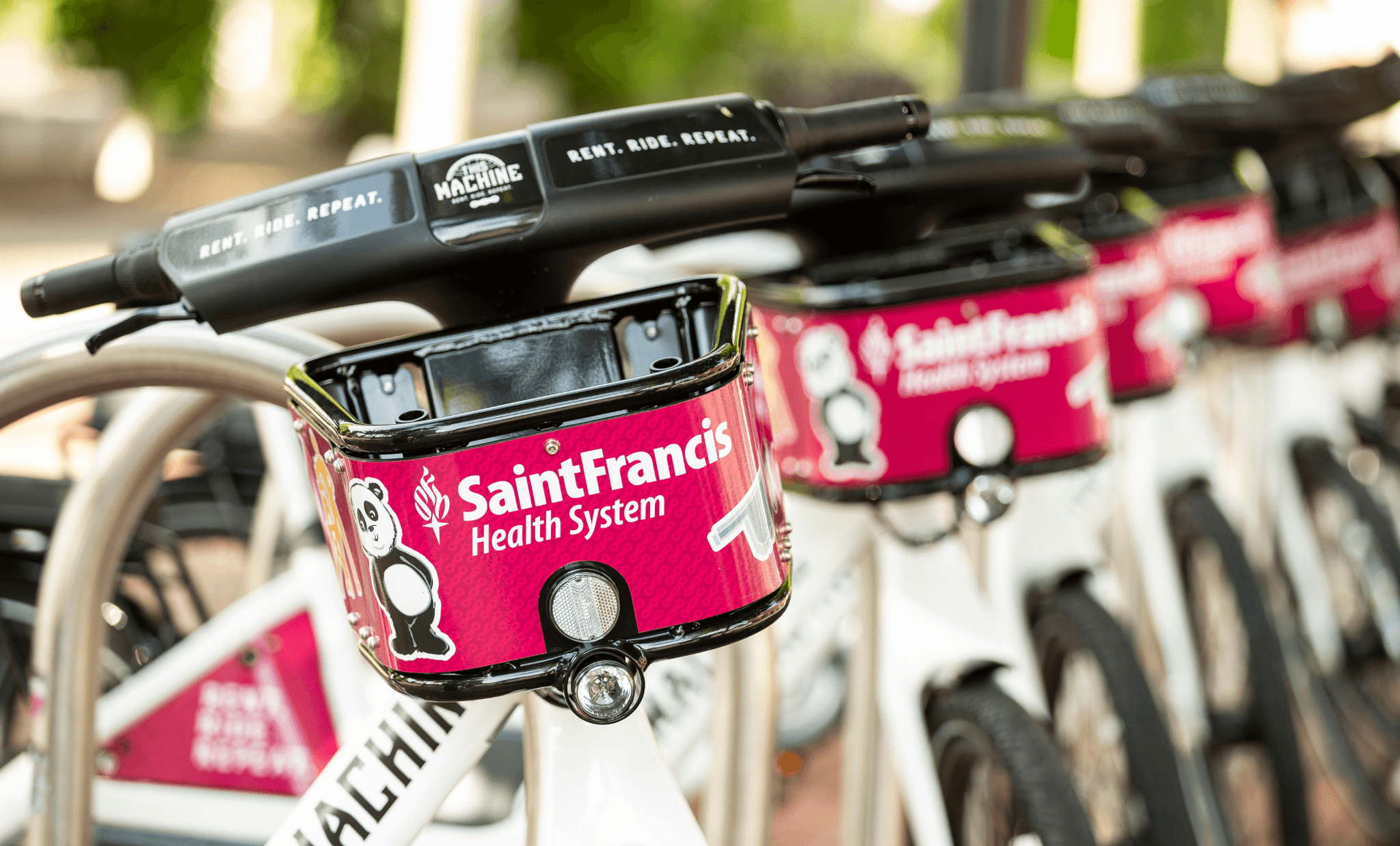 A row of bicycles with Saint Francis imagery on a bright pink basket