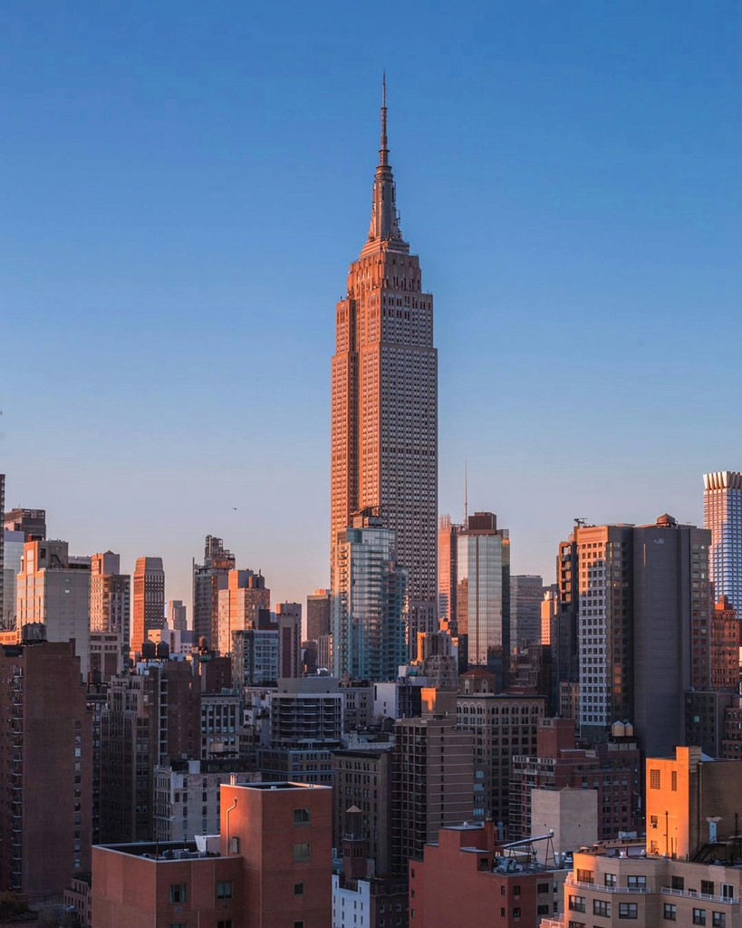 Portrait of a woman with long red hair and closed eyes, gently touching her face with both hands