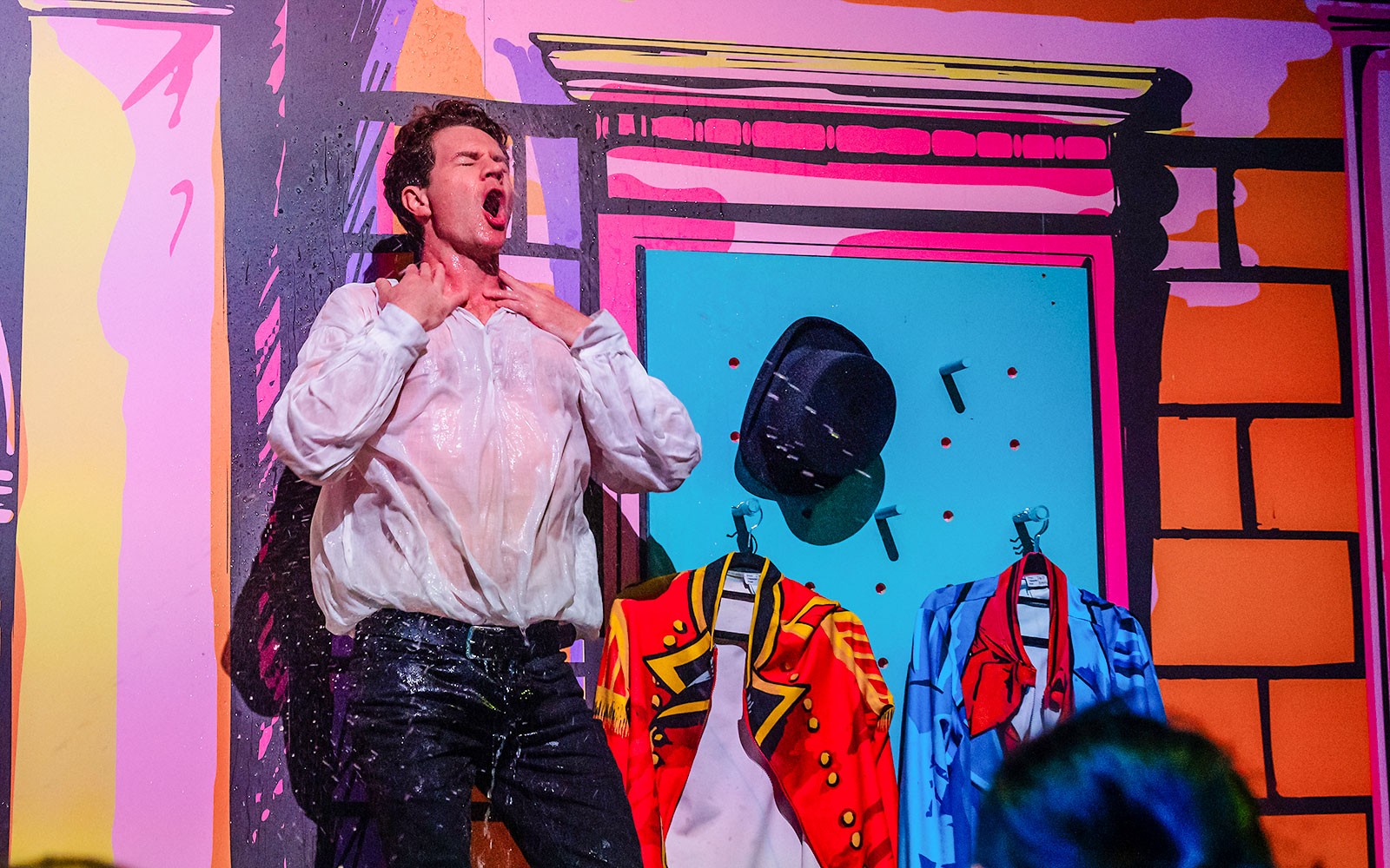 舞台上的表演者穿着湿透的衬衫，搭配色彩缤纷的服装，与《骄傲与偏见》有关。