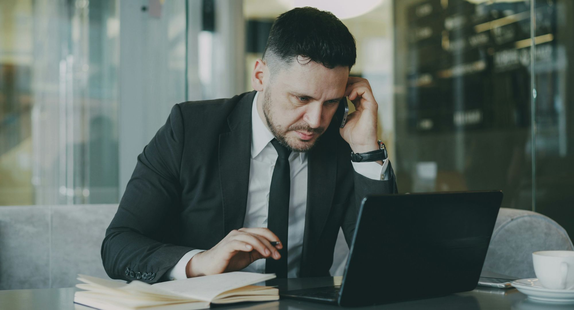 homem de terno trabalhando no notebook numa mesa
